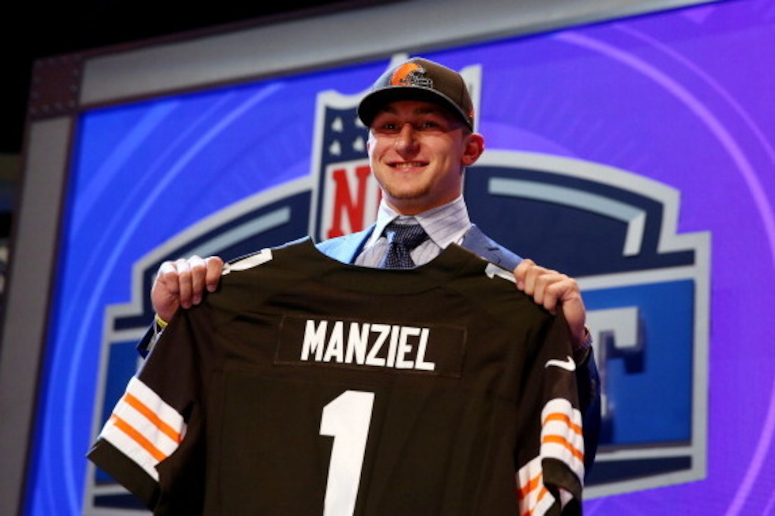 NEW YORK, NY - MAY 08:  Johnny Manziel of the Texas A&M Aggies poses with a jersey after he was picked #22 overall by the Cleveland Browns during the first round of the 2014 NFL Draft at Radio City Music Hall on May 8, 2014 in New York City.  (Photo by El