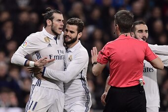 TOPSHOT - Real Madrid's Welsh forward Gareth Bale (L) argues with the referee as Real Madrid's defender Nacho Fernandez (2ndL) tries to stop him during the Spanish league football match Real Madrid CF vs UD Las Palmas at the Santiago Bernabeu stadium in M