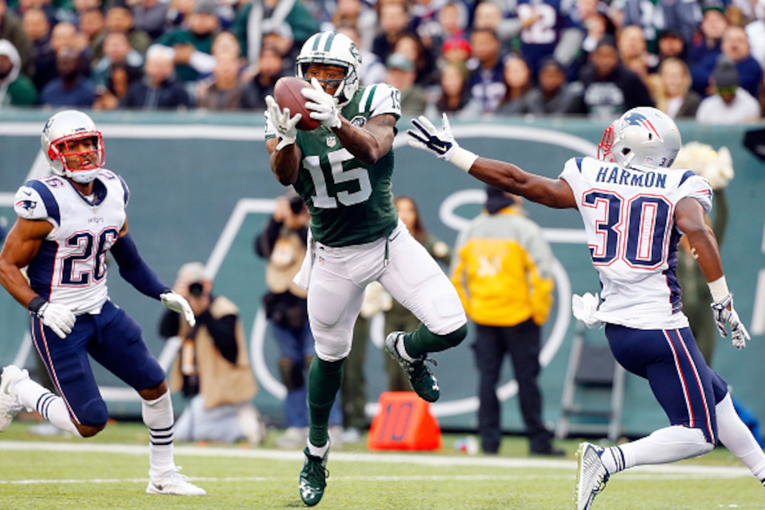 EAST RUTHERFORD, NJ - DECEMBER 27:  (NEW YORK DAILIES OUT)     Brandon Marshall #15 of the New York Jets hauls in a touchdown reception against  Logan Ryan #26 and  Duron Harmon #30 of the New England Patriots on December 27, 2015 at MetLife Stadium in Ea