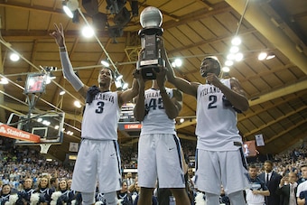 PHILADELPHIA, PA - FEBRUARY 25: Josh Hart #3, Darryl Reynolds #45, and Kris Jenkins #2 of the Villanova Wildcats celebrate with the regular season Big East Conference trophy at the end of the game against the Creighton Bluejays at the Pavilion on February