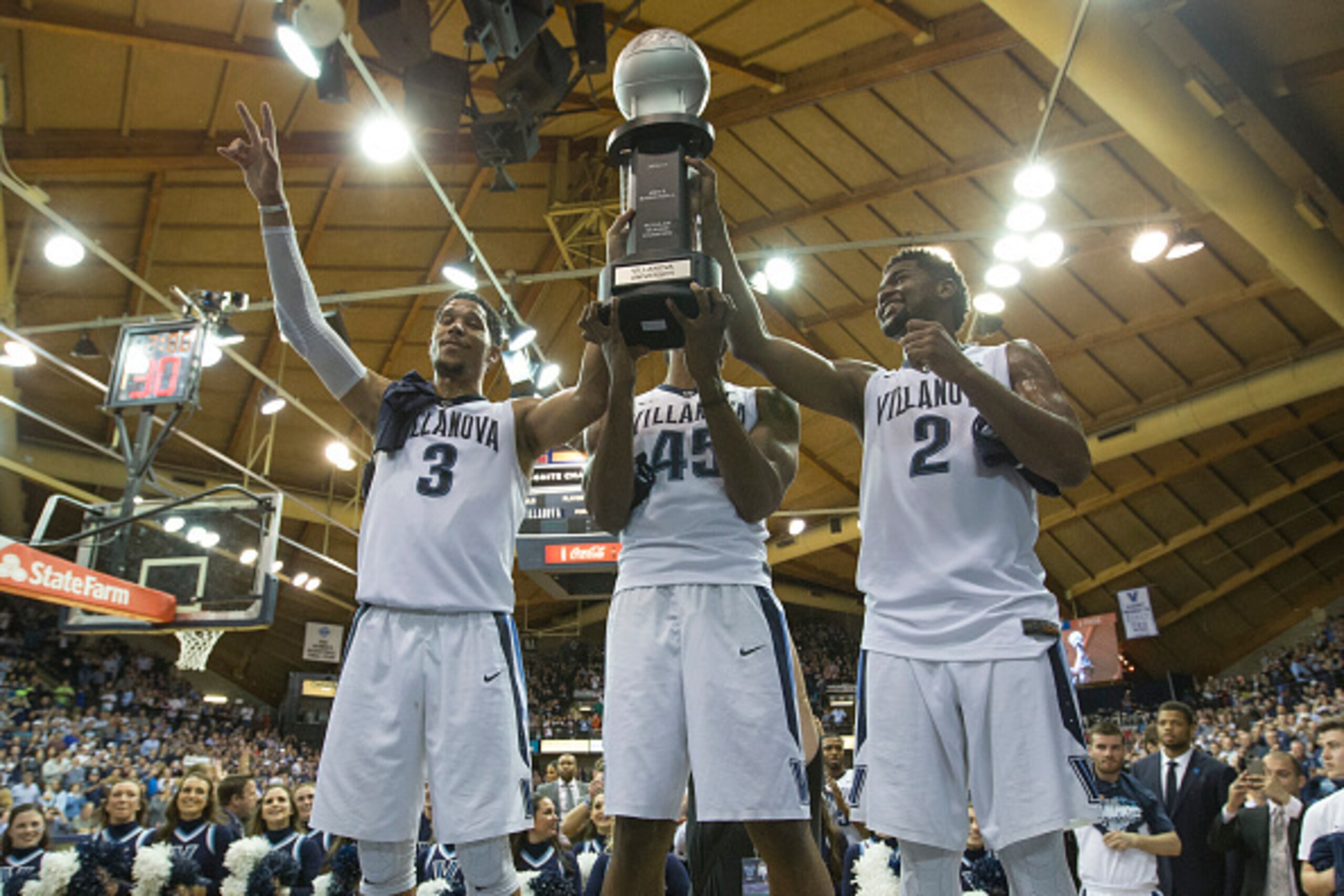 PHILADELPHIA, PA - FEBRUARY 25: Josh Hart #3, Darryl Reynolds #45, and Kris Jenkins #2 of the Villanova Wildcats celebrate with the regular season Big East Conference trophy at the end of the game against the Creighton Bluejays at the Pavilion on February