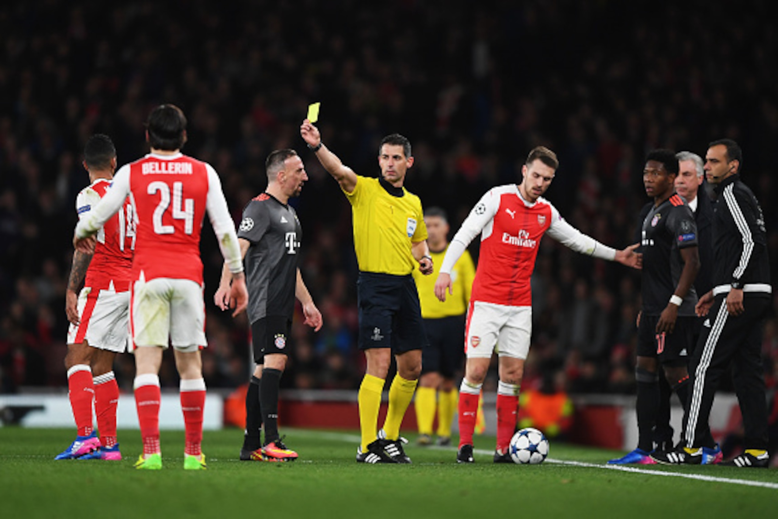 LONDON, ENGLAND - MARCH 07:  Referee Anastasios Sidiropoulos shows a yellow card to Theo Walcott of Arsenal (L) during the UEFA Champions League Round of 16 second leg match between Arsenal FC and FC Bayern Muenchen at Emirates Stadium on March 7, 2017 in