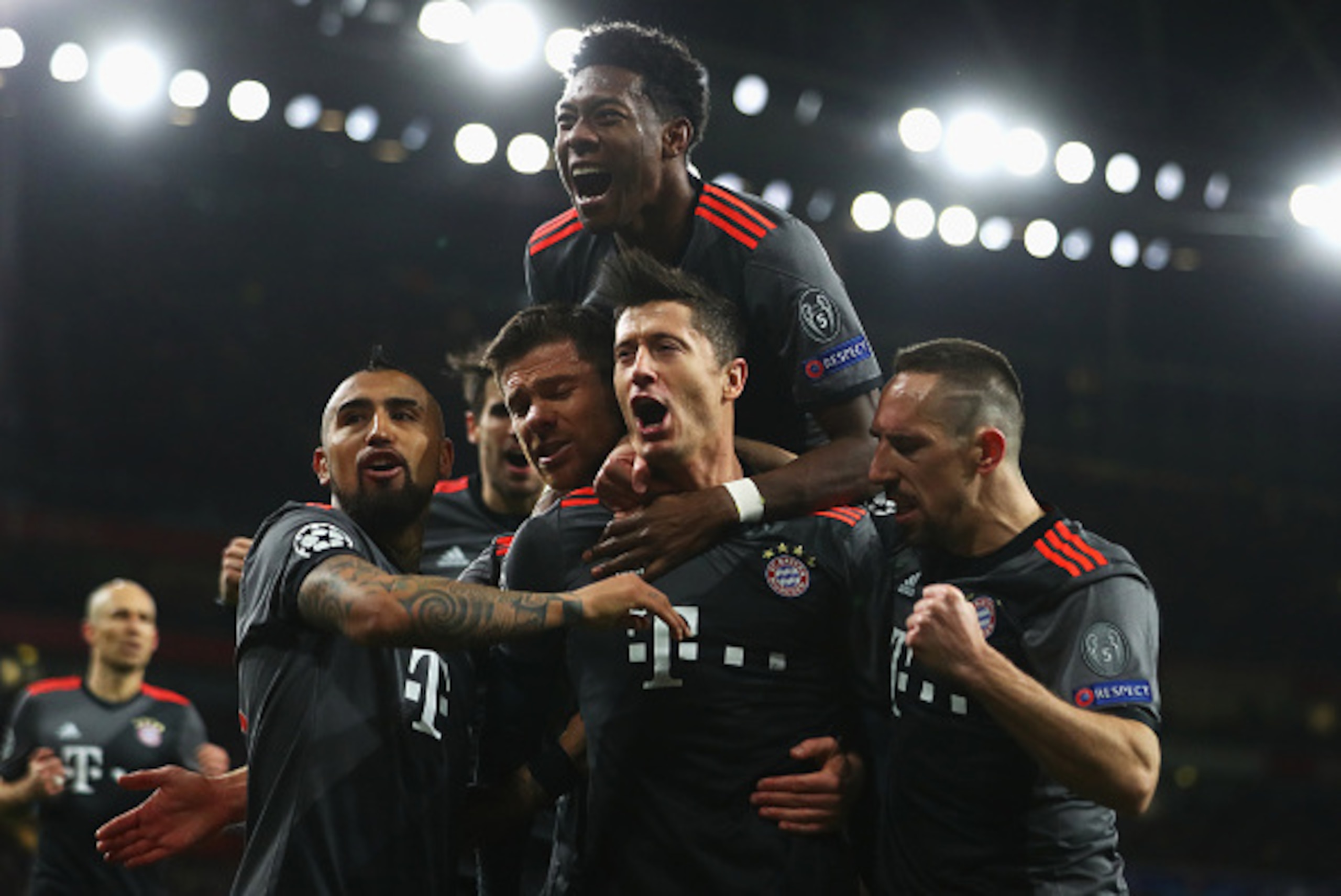 LONDON, ENGLAND - MARCH 07:  Robert Lewandowski of Bayern Muenchen (2R) celebrates with team mates as he scores their first goal from a penalty during the UEFA Champions League Round of 16 second leg match between Arsenal FC and FC Bayern Muenchen at Emir