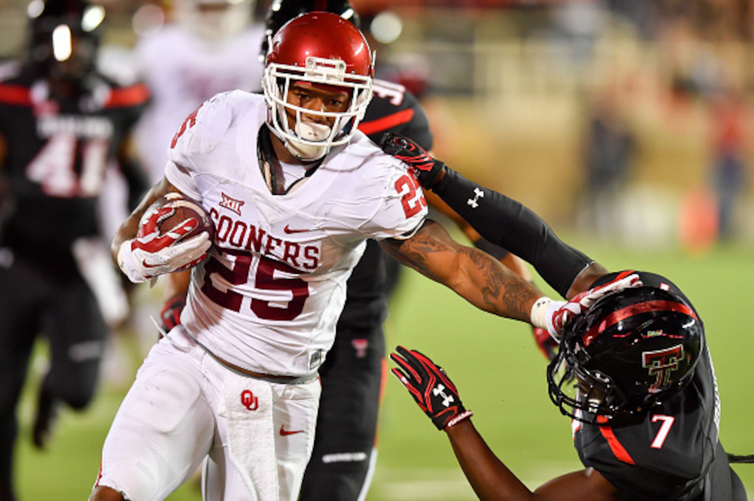 LUBBOCK, TX - OCTOBER 22: Joe Mixon #25 of the Oklahoma Sooners gets past Jah'Shawn Johnson #7 of the Texas Tech Red Raiders during the first half of the game between the Texas Tech Red Raiders and the Oklahoma Sooners on October 22, 2016 at AT&T Jones St LUBBOCK, TX - OCTOBER 22: Joe Mixon #25 of the Oklahoma Sooners gets past Jah'Shawn Johnson #7 of the Texas Tech Red Raiders during the first half of the game between the Texas Tech Red Raiders and the Oklahoma Sooners on October 22, 2016 at AT&T Jones St