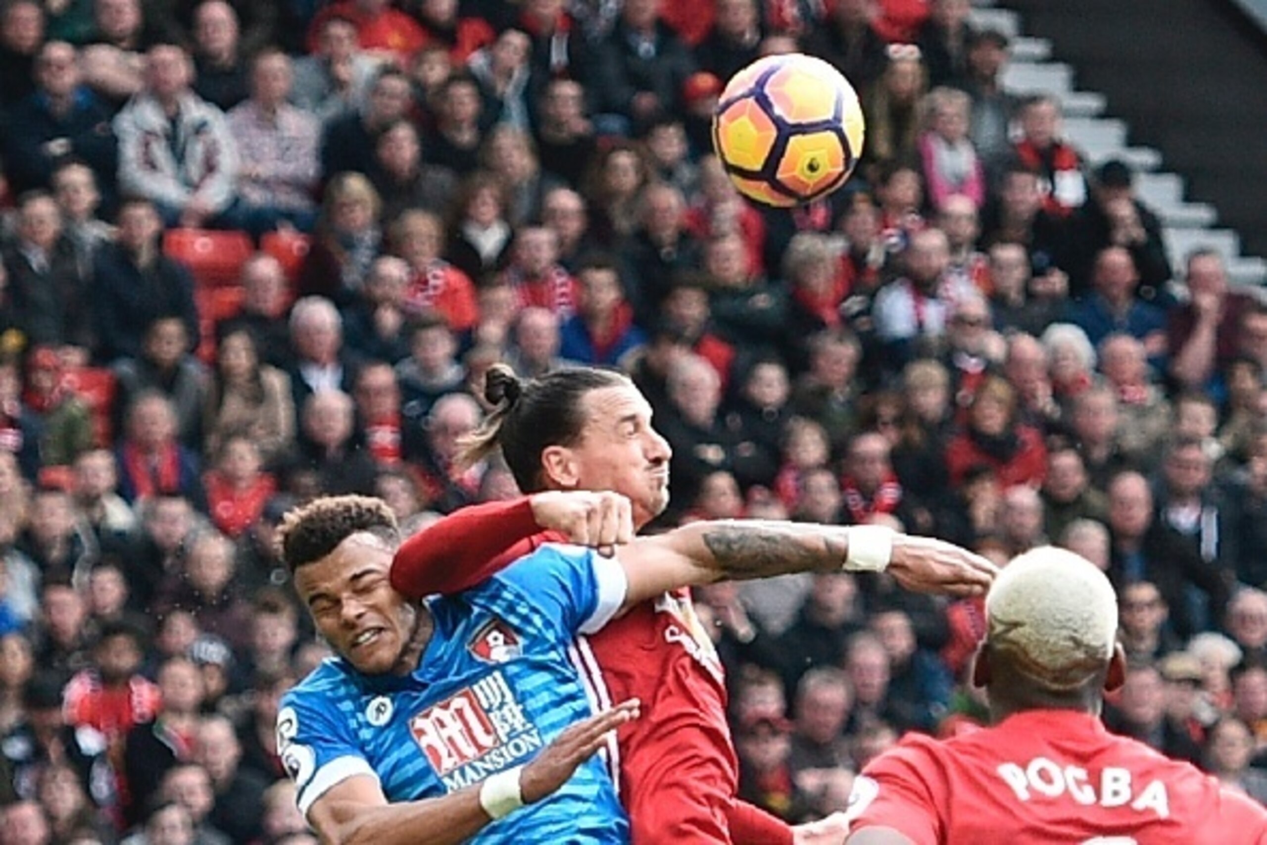 Manchester United's Swedish striker Zlatan Ibrahimovic (C) clashes in the air with Bournemouth's English defender Tyrone Mings (L) during the English Premier League football match between Manchester United and Bournemouth at Old Trafford in Manchester, no