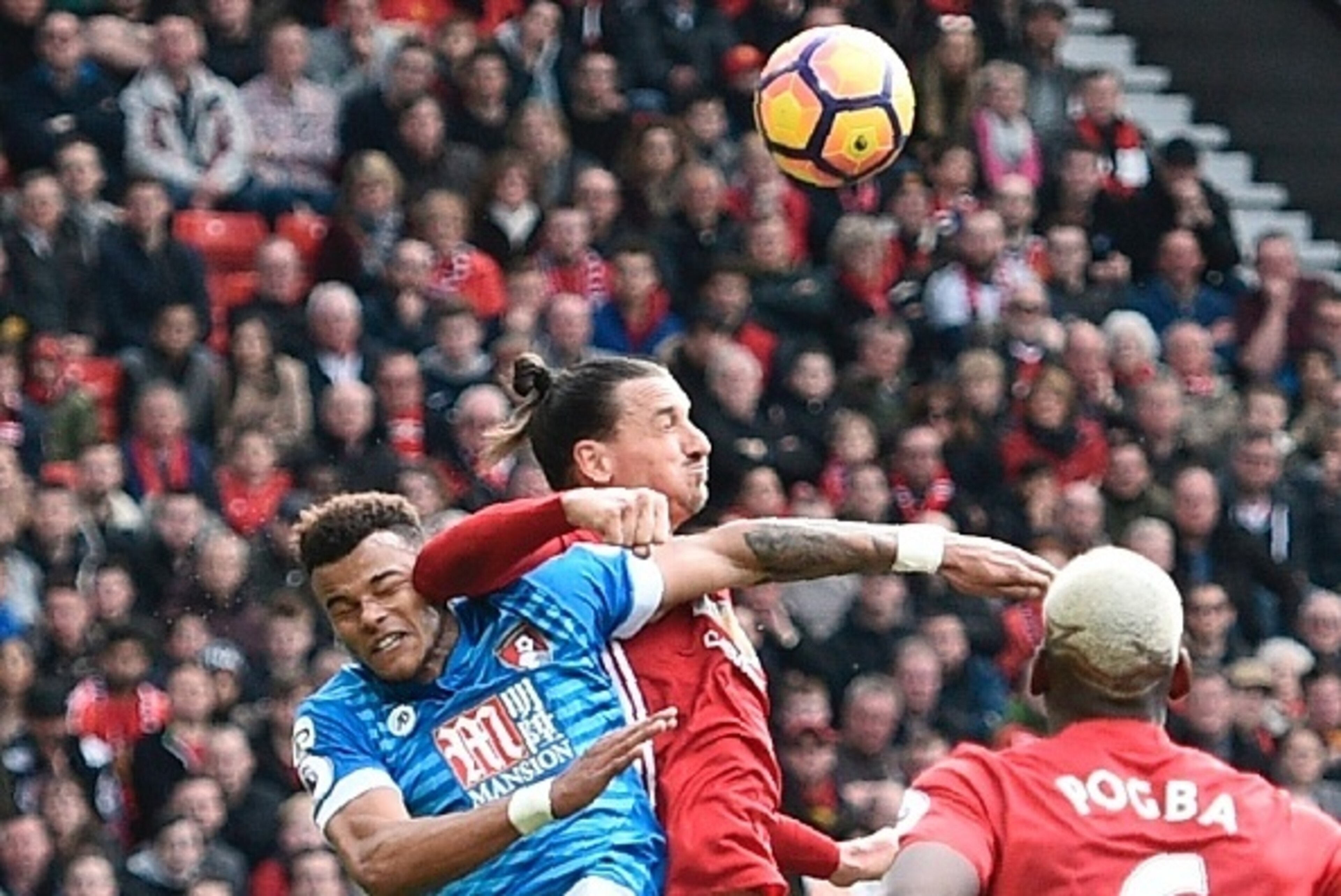Manchester United's Swedish striker Zlatan Ibrahimovic (C) clashes in the air with Bournemouth's English defender Tyrone Mings (L) during the English Premier League football match between Manchester United and Bournemouth at Old Trafford in Manchester, no