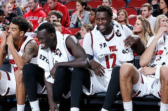 LOUISVILLE, KY - NOVEMBER 11: Mangok Mathiang #12 of the Louisville Cardinals jokes with teammates Deng Adel #22, Anas Mahmoud #14 and David Levitch #23 in the second half of the game against the Evansville Purple Aces at KFC YUM! Center on November 11, 2