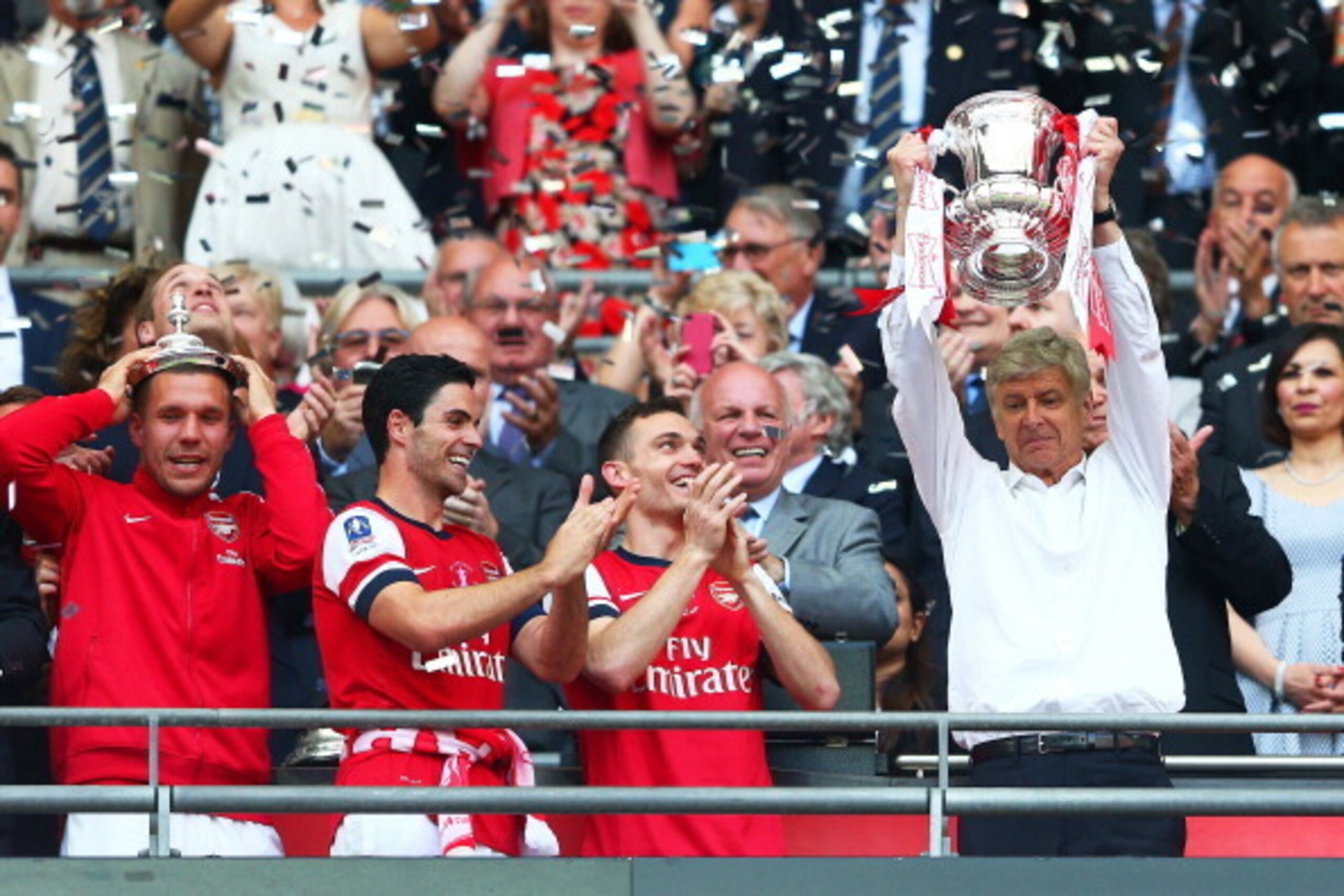 LONDON, ENGLAND - MAY 17: Arsene Wenger manager of Arsenal (R) lifts the trophy in celebration alongside Lukas Podolski (L), Mikel Arteta (2L) and Thomas Vermaelen (2R) after the FA Cup with Budweiser Final match between Arsenal and Hull City at Wembley LONDON, ENGLAND - MAY 17: Arsene Wenger manager of Arsenal (R) lifts the trophy in celebration alongside Lukas Podolski (L), Mikel Arteta (2L) and Thomas Vermaelen (2R) after the FA Cup with Budweiser Final match between Arsenal and Hull City at Wembley