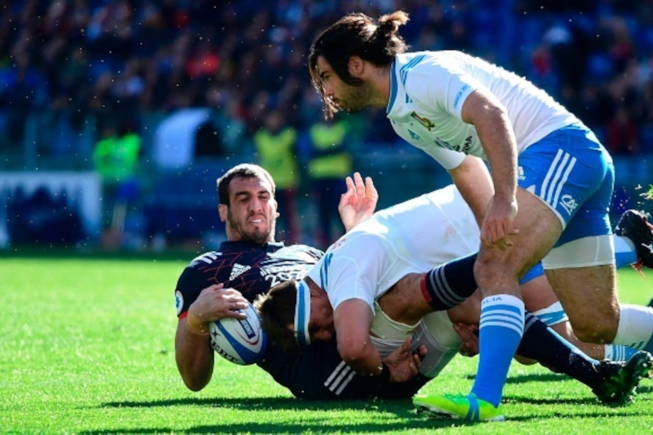 France's lock Yoann Maestri (L) is tackled by Italian players during the International Six Nations rugby union match Italy vs France on March 11, 2017 at the Olympic Stadium in Rome.  / AFP PHOTO / Miguel MEDINA        (Photo credit should read MIGUEL MED