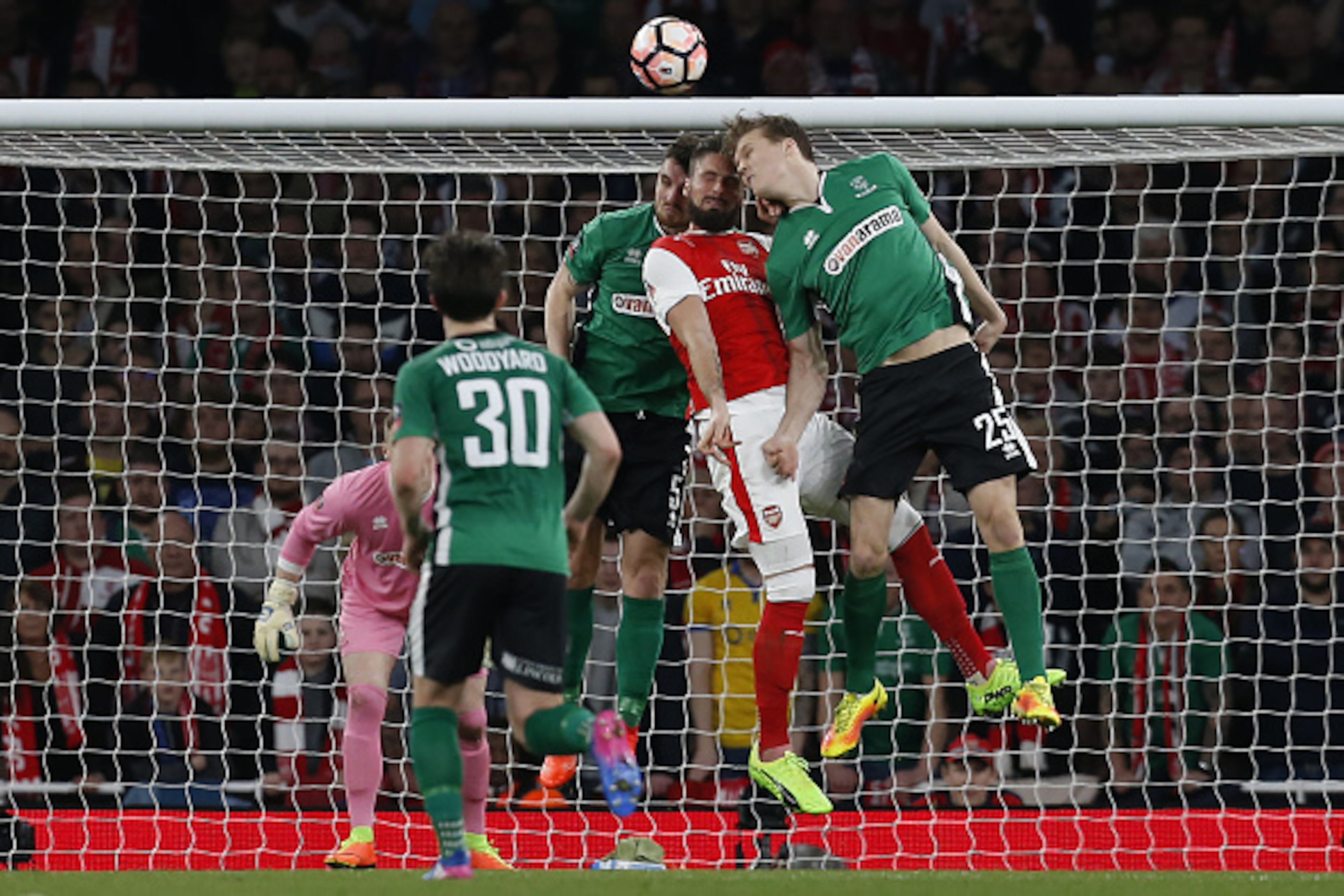 Arsenal's French striker Olivier Giroud (2nd R) is hurt in this clash with Lincoln City's English defender Luke Waterfall and Lincoln City's English defender Sean Raggett (R) during the English FA cup quarter final football match between Arsenal and Linco