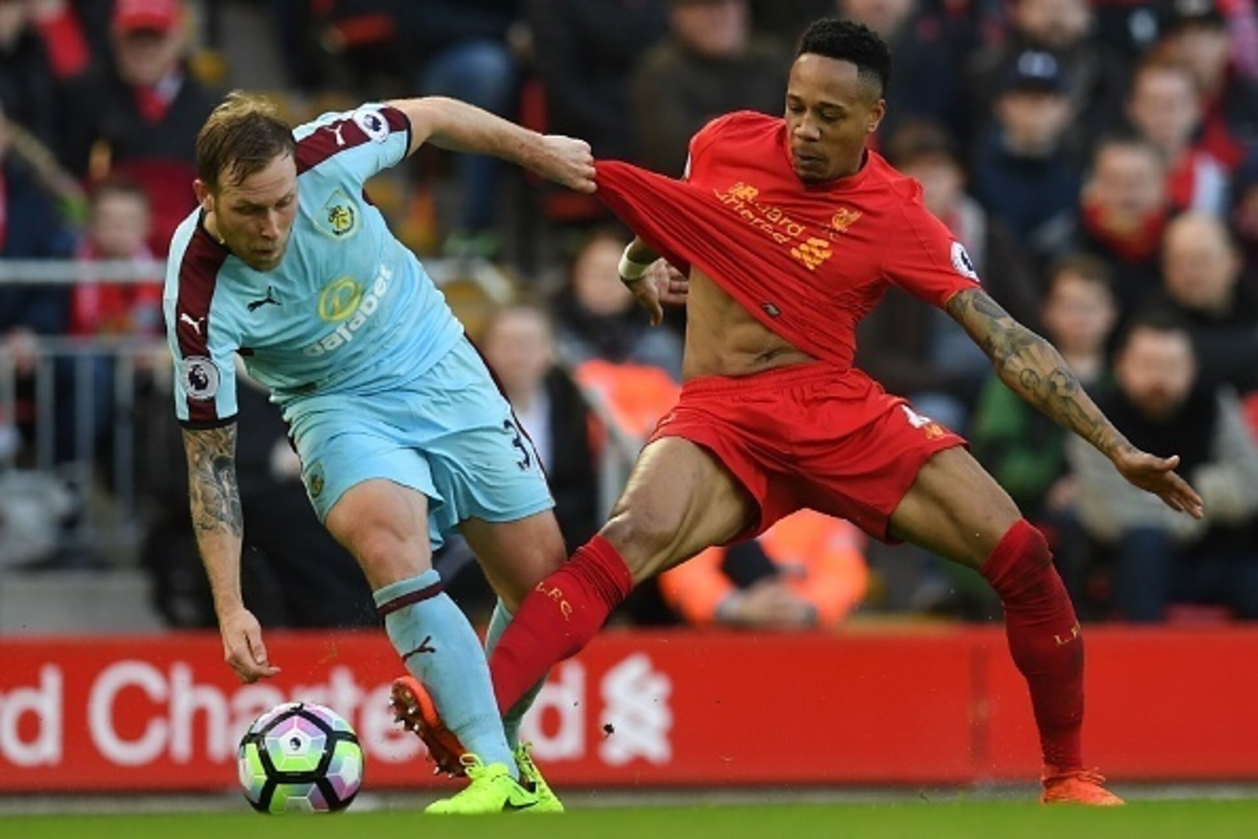 Burnley's Scottish midfielder Scott Arfield (L) vies with Liverpool's English defender Nathaniel Clyne during the English Premier League football match between Liverpool and Burnley at Anfield in Liverpool, north west England on March 12, 2017. / AFP PHOT
