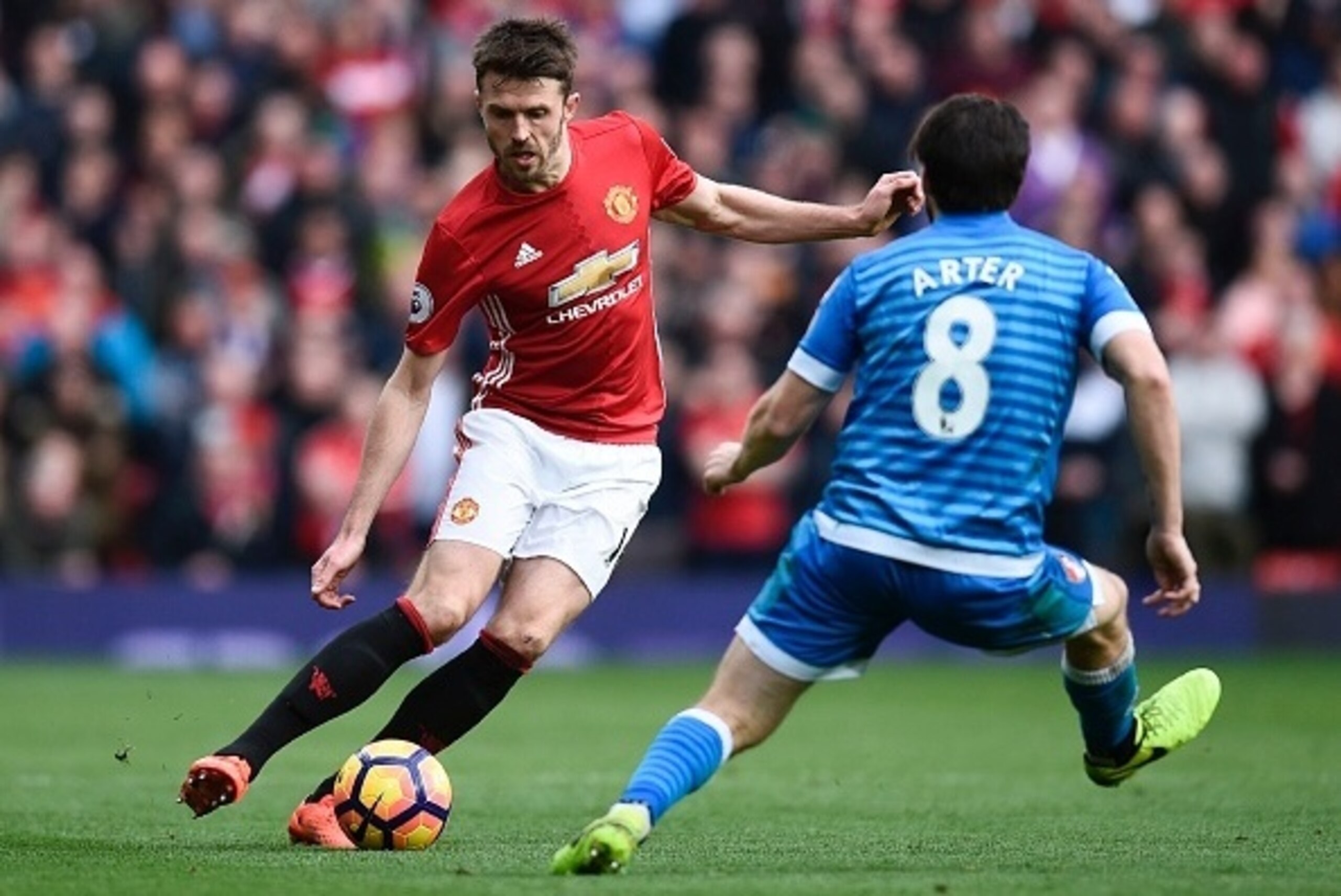 Manchester United's English midfielder Michael Carrick (L) takes on Bournemouth's English-born Irish midfielder Harry Arter (R) during the English Premier League football match between Manchester United and Bournemouth at Old Trafford in Manchester, north