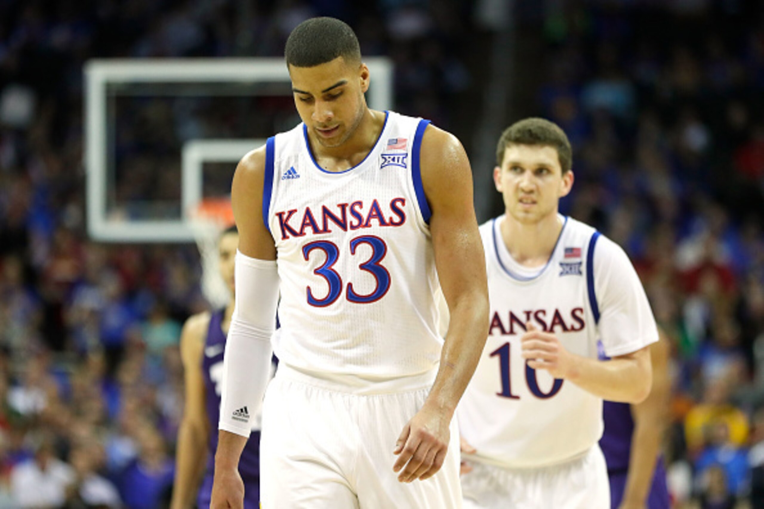 KANSAS CITY, MO - MARCH 09:  Landen Lucas #33 and Sviatoslav Mykhailiuk #10 of the Kansas Jayhawks walk off the court during a timeout in the quarterfinal game of the Big 12 Basketball Tournament against the TCU Horned Frogs at the Sprint Center on March 