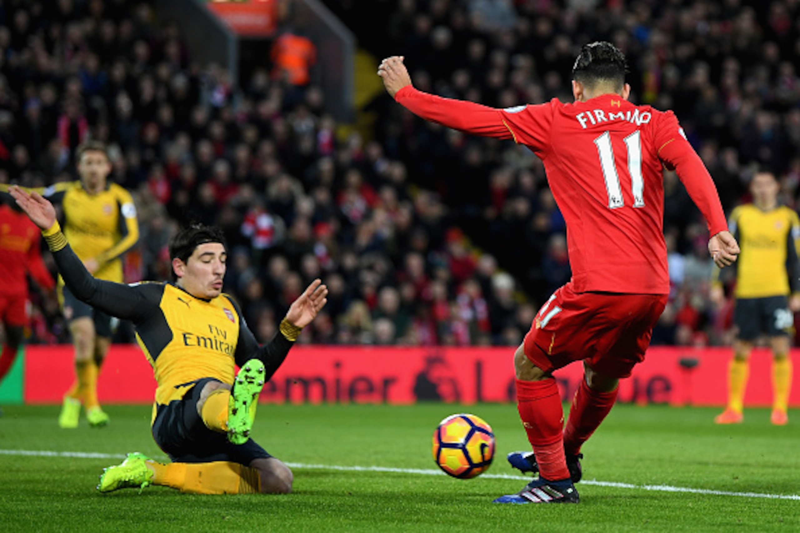 LIVERPOOL, ENGLAND - MARCH 04: Roberto Firmino of Liverpool (R) scores his sides first goal as Hector Bellerin of Arsenal (L) attempts to block during the Premier League match between Liverpool and Arsenal at Anfield on March 4, 2017 in Liverpool, England LIVERPOOL, ENGLAND - MARCH 04: Roberto Firmino of Liverpool (R) scores his sides first goal as Hector Bellerin of Arsenal (L) attempts to block during the Premier League match between Liverpool and Arsenal at Anfield on March 4, 2017 in Liverpool, England
