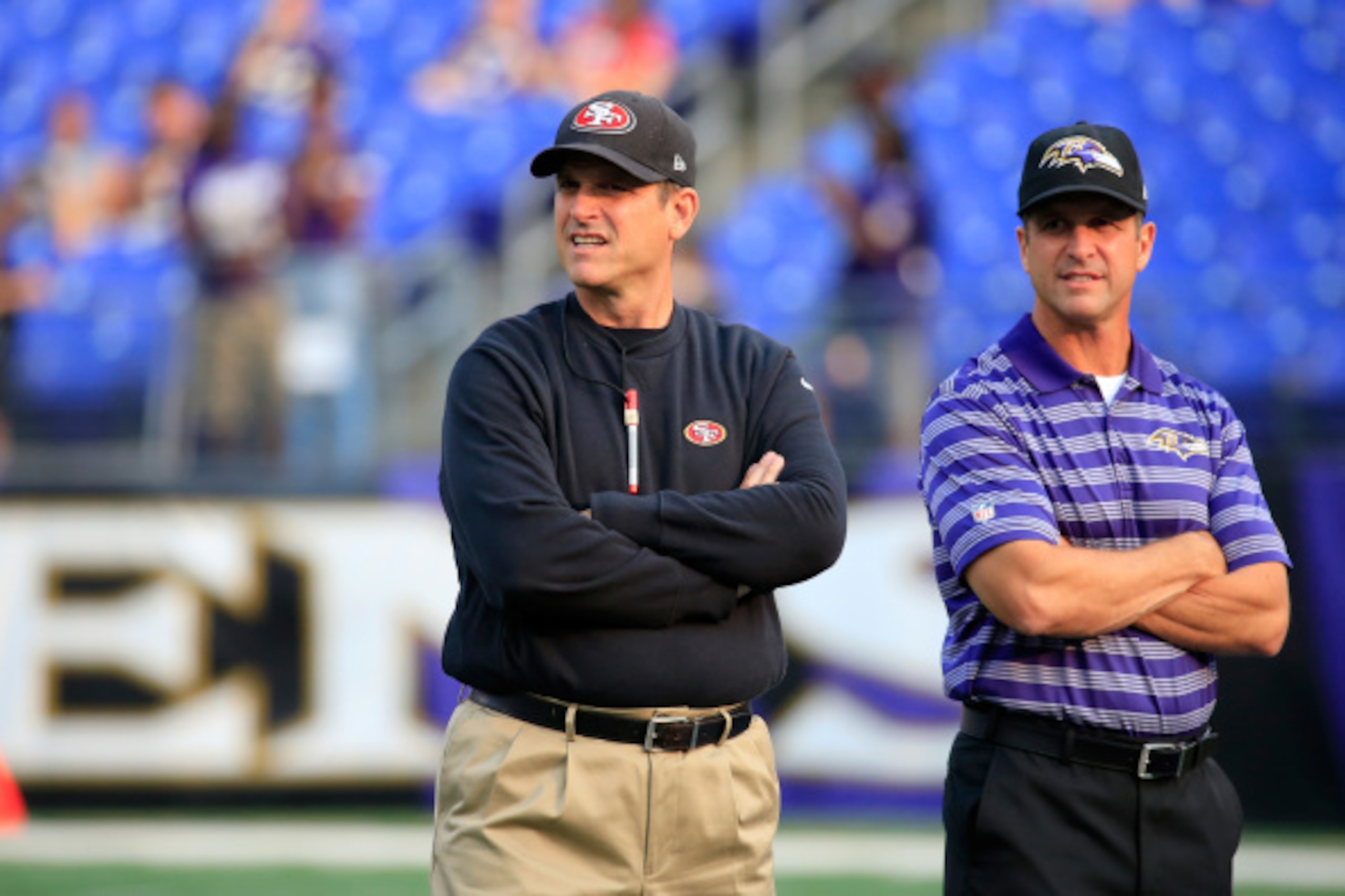 BALTIMORE, MD - AUGUST 07:  Head coach Jim Harbaugh of the San Francisco 49ers and his brother head coach John Harbaugh of the Baltimore Ravens talk before the start of their NFL pre-season game at M&T Bank Stadium on August 7, 2014 in Baltimore, Maryland