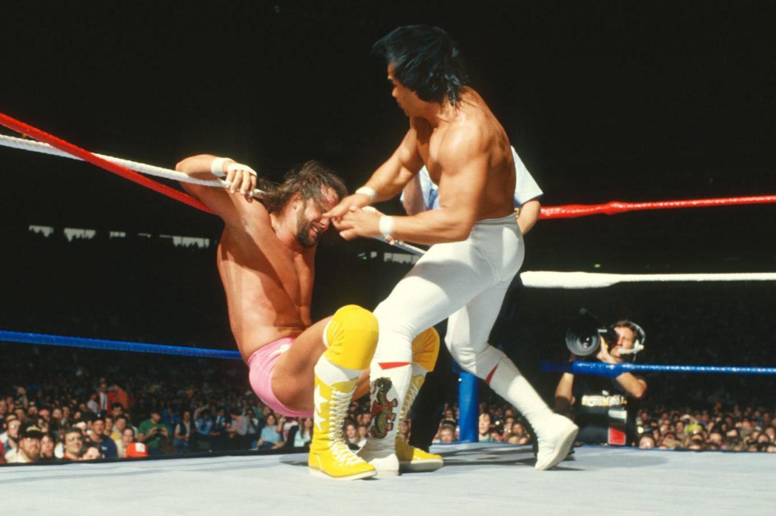 Ricky Steamboat attacks a tied-up Randy Savage.