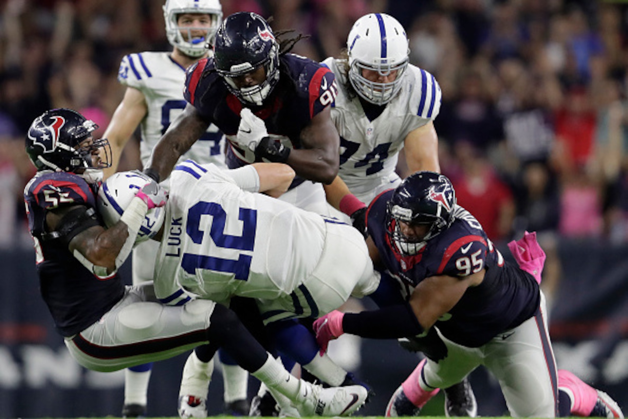 HOUSTON, TX - OCTOBER 16: Andrew Luck #12 of the Indianapolis Colts is sacked by Benardrick McKinney #55 of the Houston Texans along with Jadeveon Clowney #90 and Christian Covington #95 in overtime during the NFL game between the Indianapolis Colts and t
