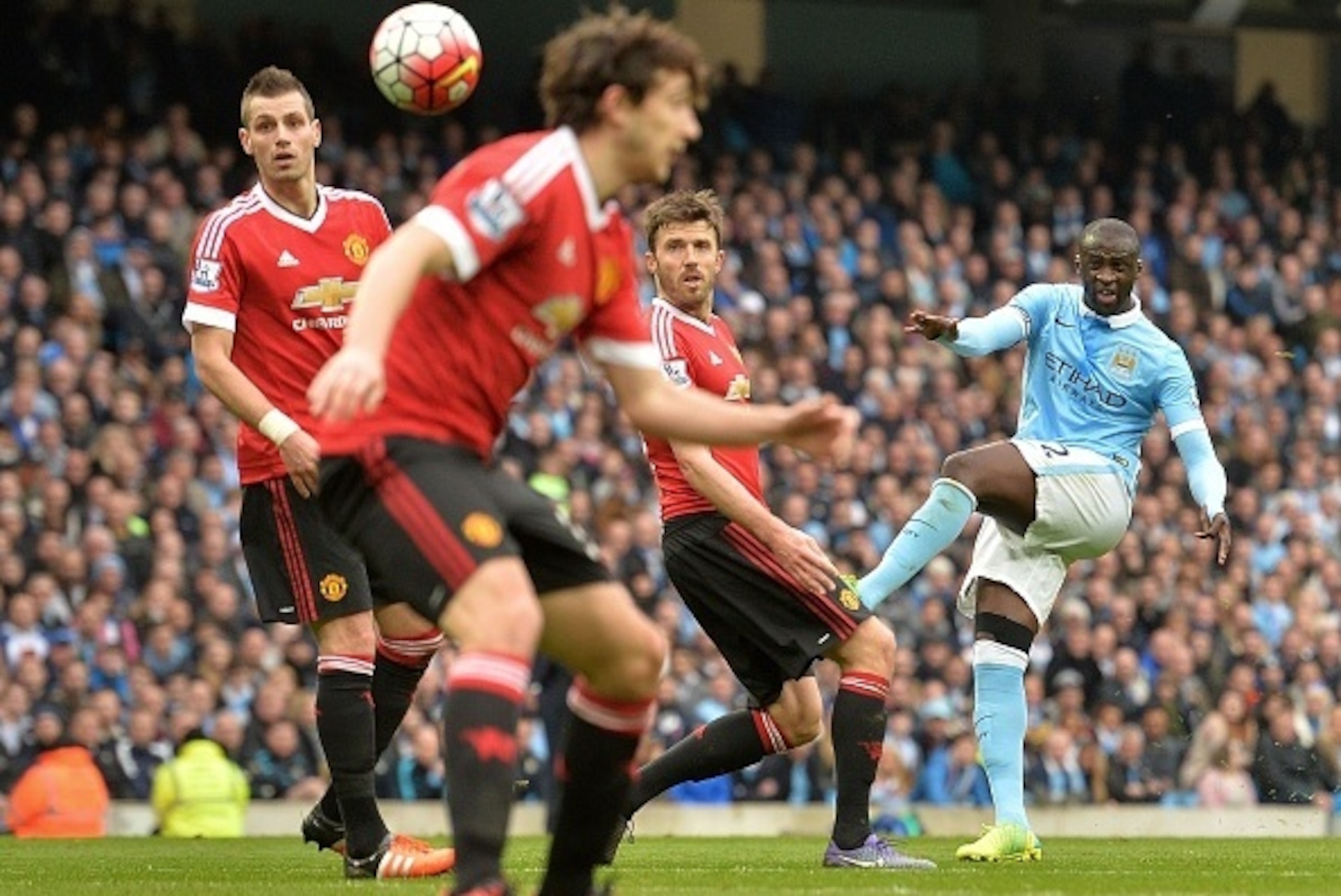 Manchester City's Ivorian midfielder and captain Yaya Toure (R) attempts a shot on goal during the English Premier League football match between Manchester City and Manchester United at the Etihad Stadium in Manchester, north west England, on March 20, 20