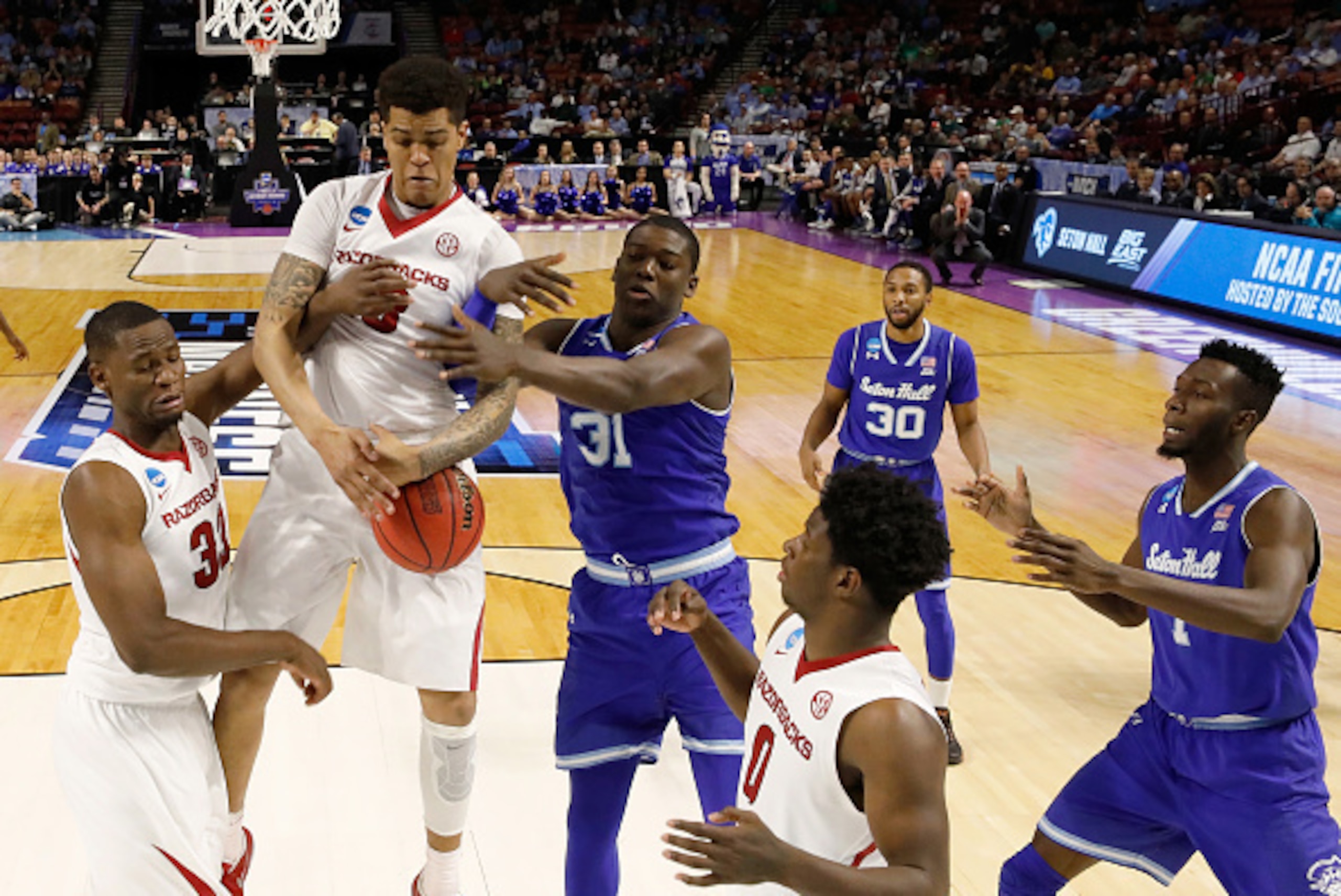 GREENVILLE, SC - MARCH 17:  Dustin Thomas #13 of the Arkansas Razorbacks and Angel Delgado #31 of the Seton Hall Pirates battle for a rebound in the first round of the 2017 NCAA Men's Basketball Tournament  at Bon Secours Wellness Arena on March 17, 2017 