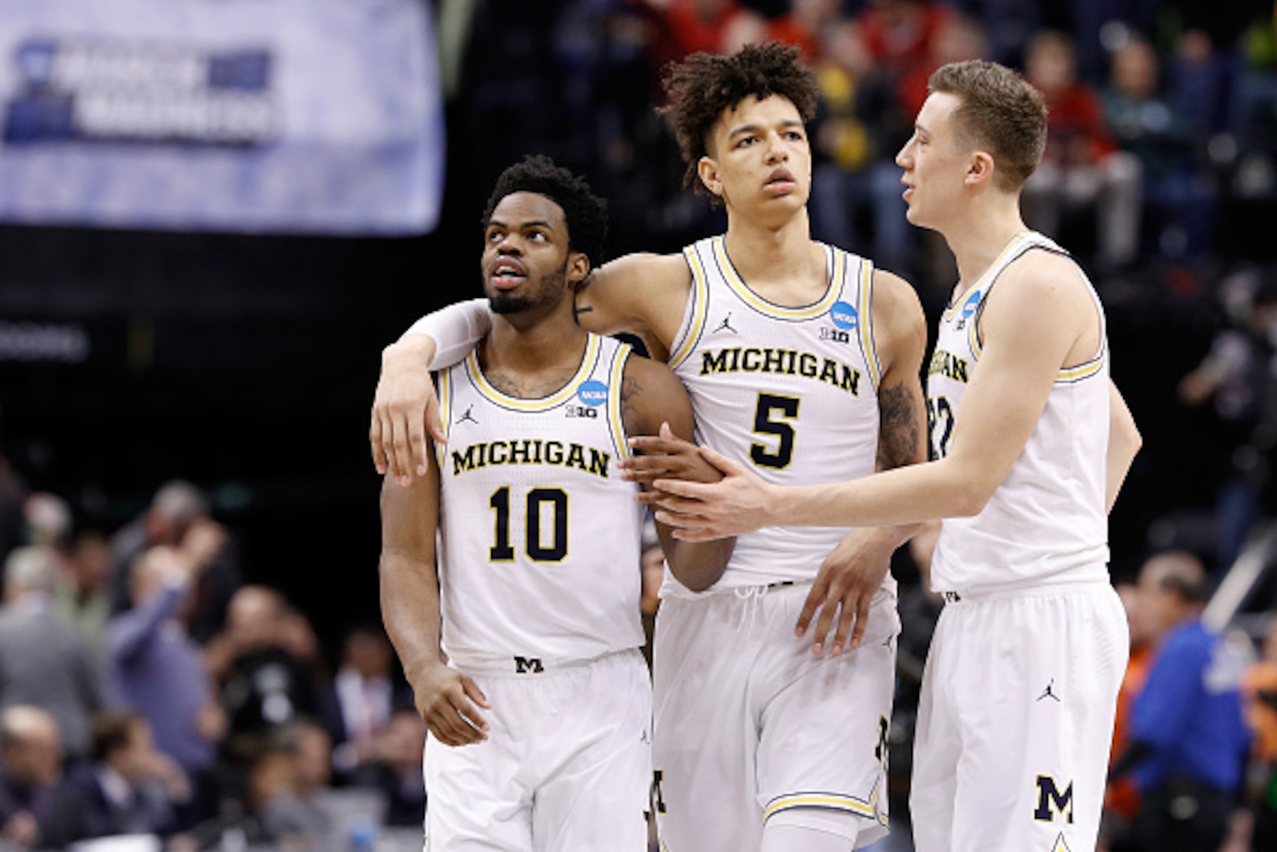 INDIANAPOLIS, IN - MARCH 17:  Derrick Walton Jr. #10 of the Michigan Wolverines celebrates with D.J. Wilson #5 and Duncan Robinson #22 against the Oklahoma State Cowboys during the first round of the 2017 NCAA Men's Basketball Tournament at Bankers Life F
