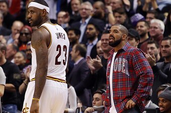 TORONTO, ON - NOVEMBER 25:  Singer Drake talks to LeBron James #23 of the Cleveland Cavaliers during an NBA game between the Cleveland Cavaliers and the Toronto Raptors at the Air Canada Centre on November 25, 2015 in Toronto, Ontario, Canada.  NOTE TO US