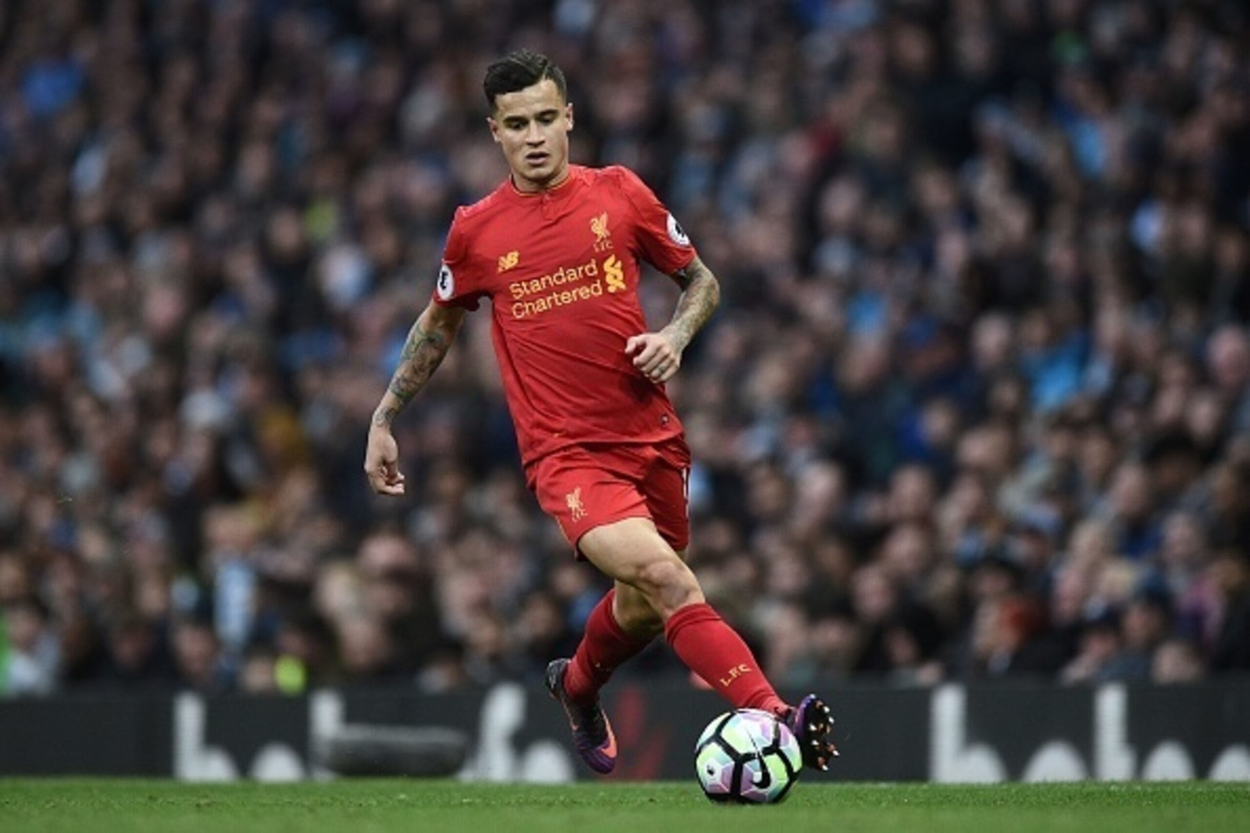 Liverpool's Brazilian midfielder Philippe Coutinho runs with the ball during the English Premier League football match between Manchester City and Liverpool at the Etihad Stadium in Manchester, north west England, on March 19, 2017. / AFP PHOTO / Oli SCAR