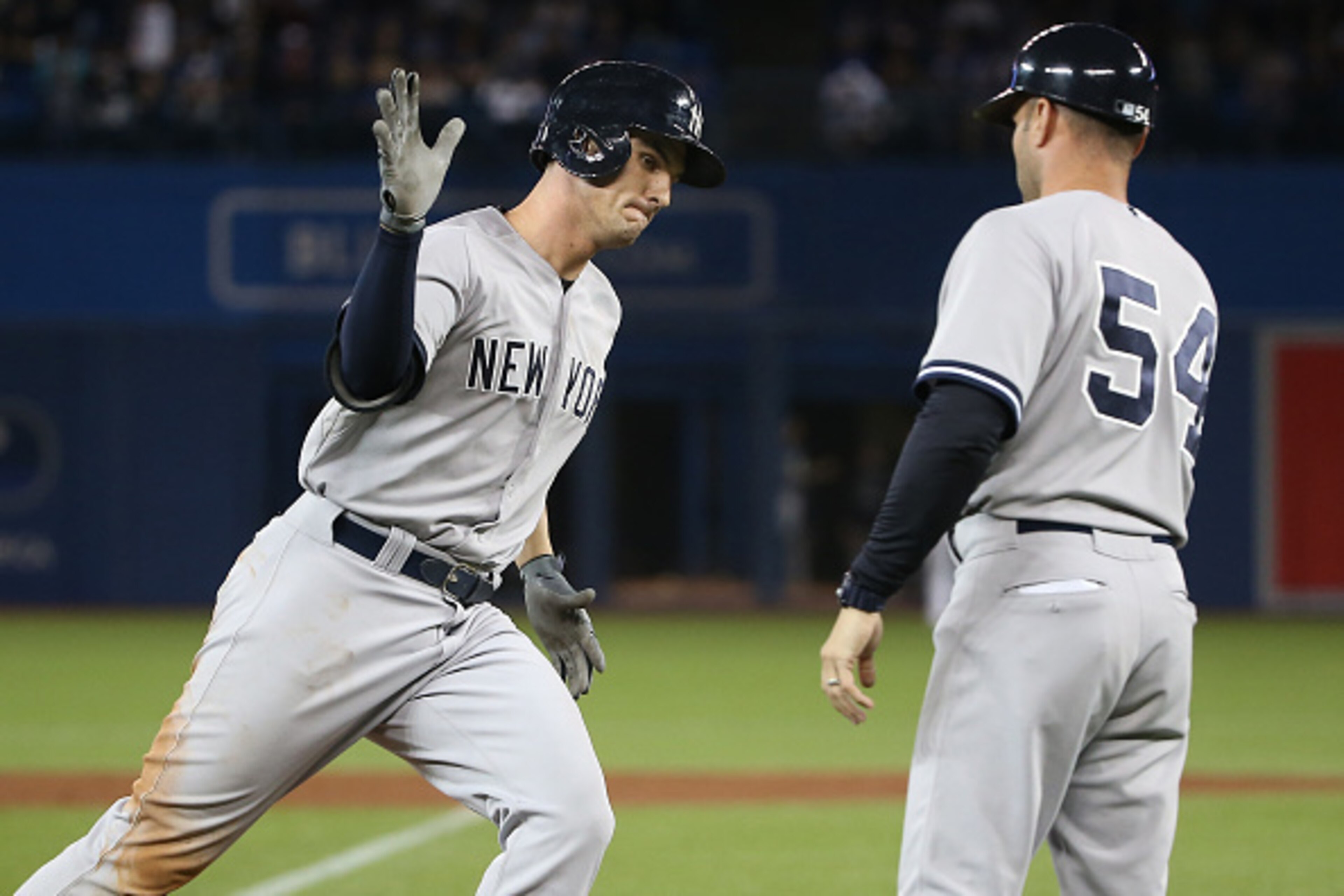 TORONTO, CANADA - SEPTEMBER 22: Greg Bird #31 of the New York Yankees is congratulated by third base coach Joe Espada #54 after hitting a three-run home run in the 10th inning during MLB game action against the Toronto Blue Jays on September 22, 2015 at R