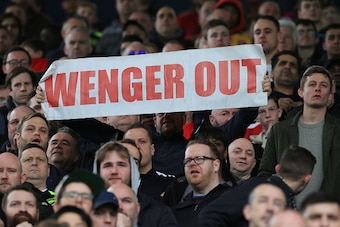 A fan holds up an anti-Arsene Wenger sign during the English Premier League football match between West Bromwich Albion and Arsenal at The Hawthorns stadium in West Bromwich, central England, on March 18, 2017.
 / AFP PHOTO / Lindsey PARNABY / RESTRICTED 