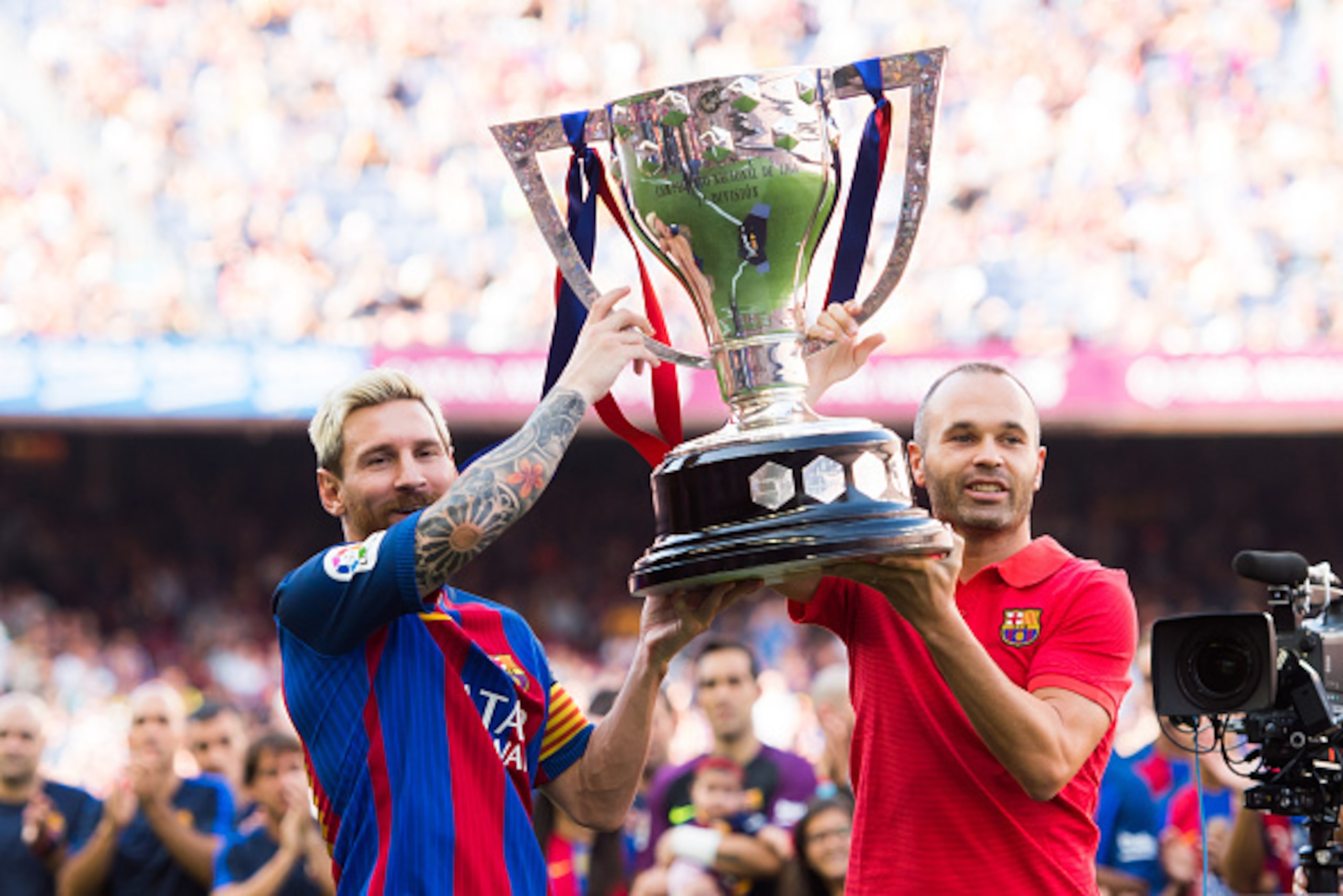 BARCELONA, SPAIN - AUGUST 20: Lionel Messi (L) and Andres Iniesta (R) of FC Barcelona lift up the Spanish La Liga 2015-2016 season trophy before the La Liga match between FC Barcelona and Real Betis Balompie at Camp Nou on August 20, 2016 in Barcelona, Sp