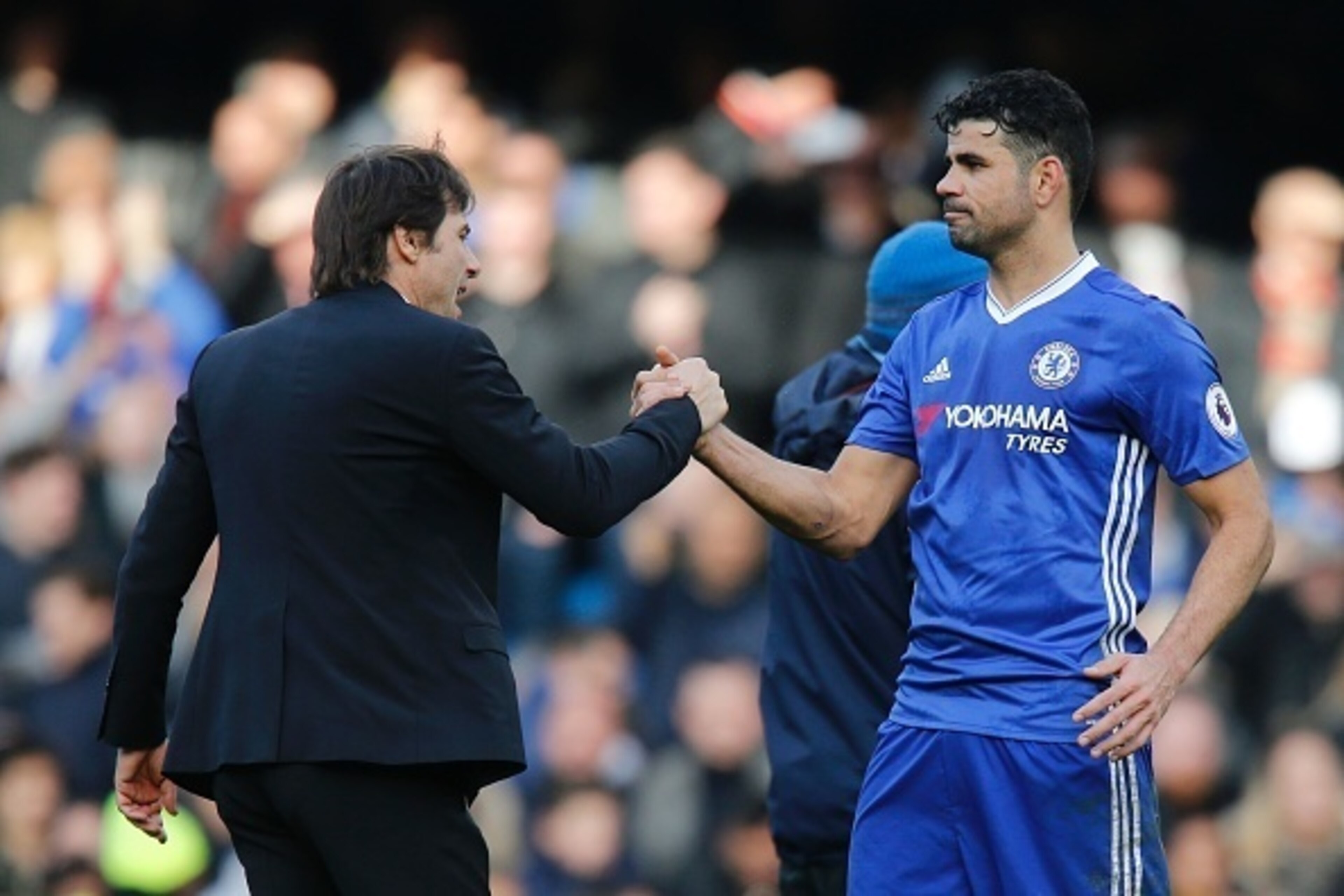 Chelsea's Italian head coach Antonio Conte (L) embraces Chelsea's Brazilian-born Spanish striker Diego Costa (R) during the English Premier League football match between Chelsea and Arsenal at Stamford Bridge in London on February 4, 2017. / AFP / Ian KIN
