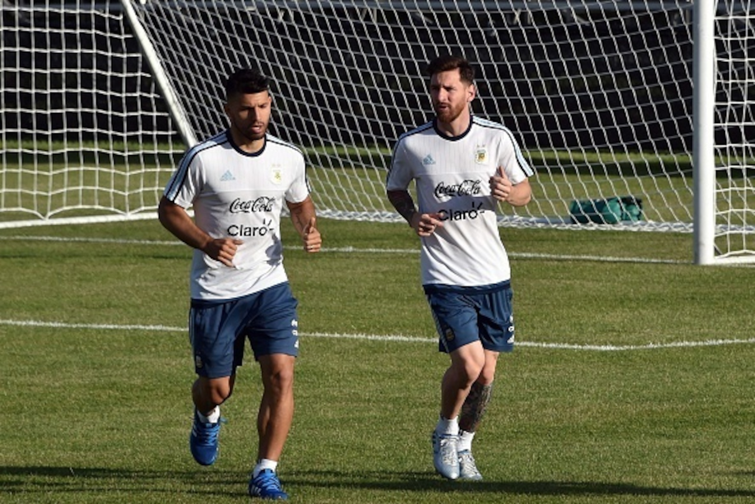 Sergio Aguero (L) and Lionel Messi (R) run during an Argentine team training session at Harvard University in Boston, Massachusetts, on June 15, 2016. 
Argentina will face Venezuela on June 18 in their quarterfinal match of the Copa America. / AFP / NELSO