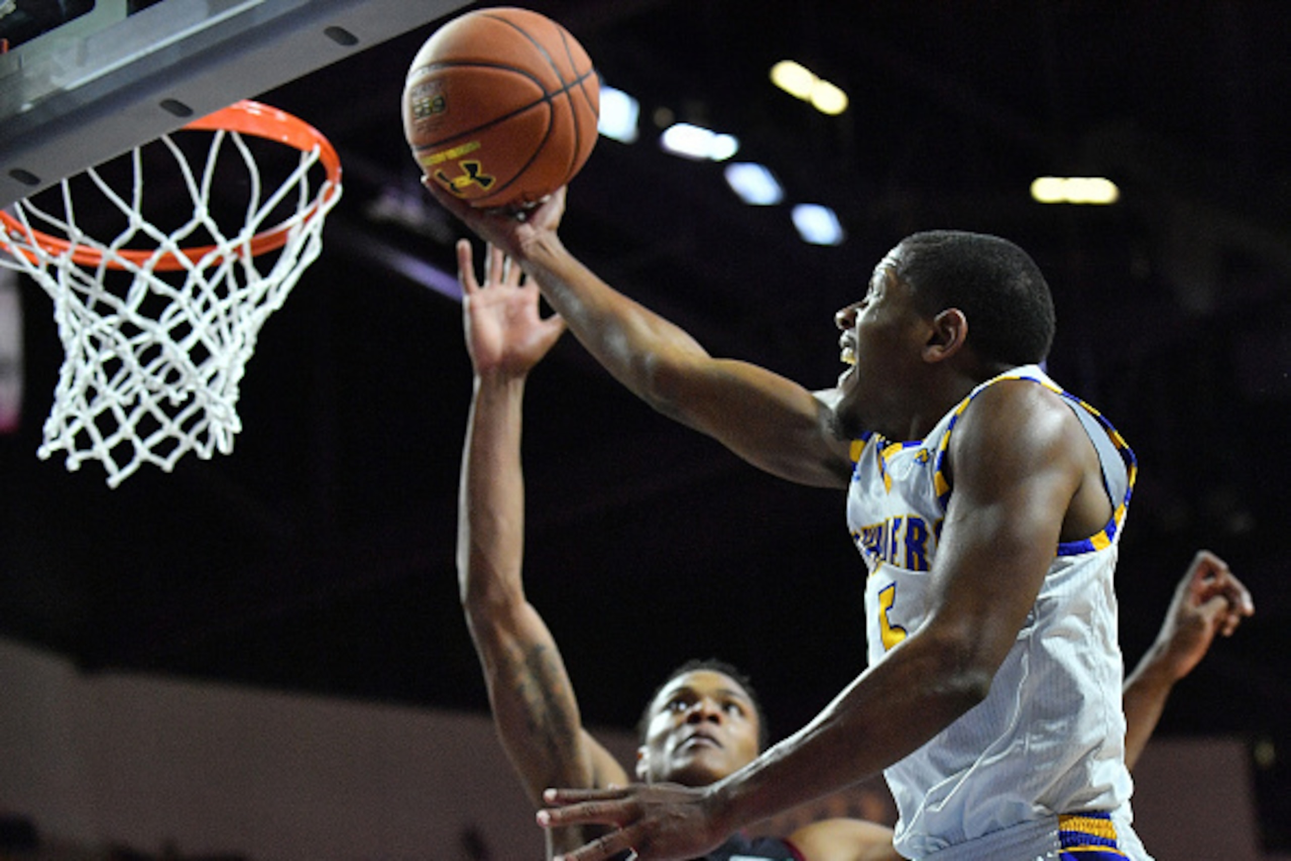 LAS VEGAS, NV - MARCH 11:  Dedrick Basile #5 of the Cal State Bakersfield Roadrunners goes up for a layup against Jemerrio Jones #10 of the New Mexico State Aggies during the championship game of the Western Athletic Conference Basketball tournament at th