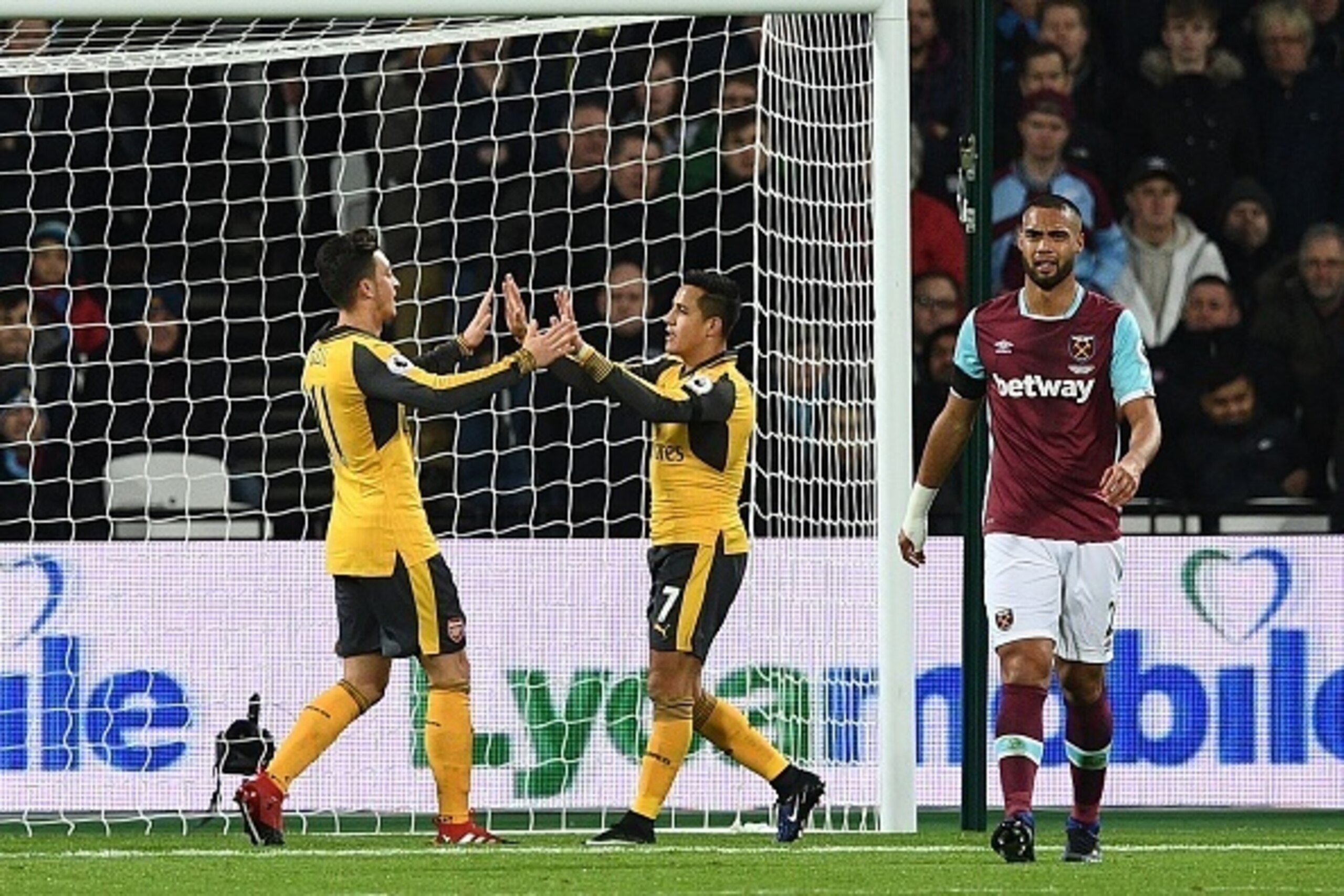 Arsenal's German midfielder Mesut Ozil (L) celebrates with Arsenal's Chilean striker Alexis Sanchez after scoring the opening goal of the English Premier League football match between West Ham United and Arsenal at The London Stadium, in east London on De Arsenal's German midfielder Mesut Ozil (L) celebrates with Arsenal's Chilean striker Alexis Sanchez after scoring the opening goal of the English Premier League football match between West Ham United and Arsenal at The London Stadium, in east London on De
