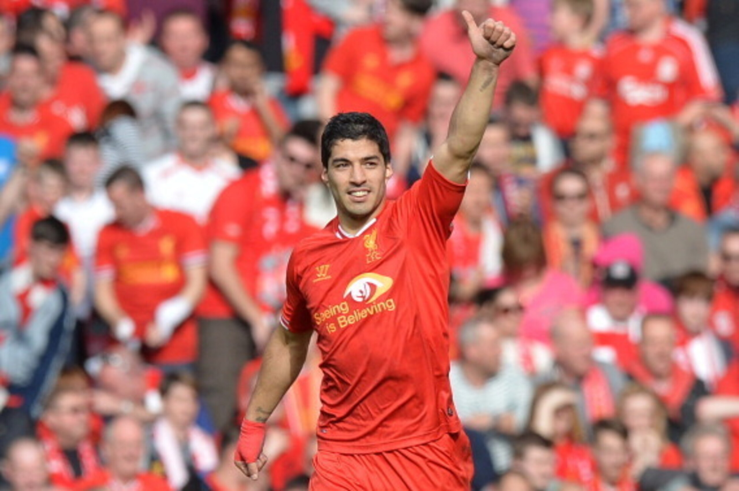Liverpool's Uruguayan striker Luis Suarez celebrates scoring his team's second goal during the English Premier League football match between Liverpool and Tottenham Hotspur at Anfield in Liverpool, northwest England on March 30, 2014. AFP PHOTO / PAUL ELL