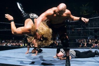 Steve Austin attacks Kevin Nash as Jack Doan lies on the canvas behind them.