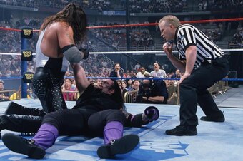 Jack Doan tries to maintain order during a WrestleMania match between Diesel and Undertaker.