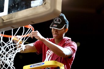 PJ Dozier celebrates by cutting down the net after defeating Florida in the East Regional final on March 26, 2017.