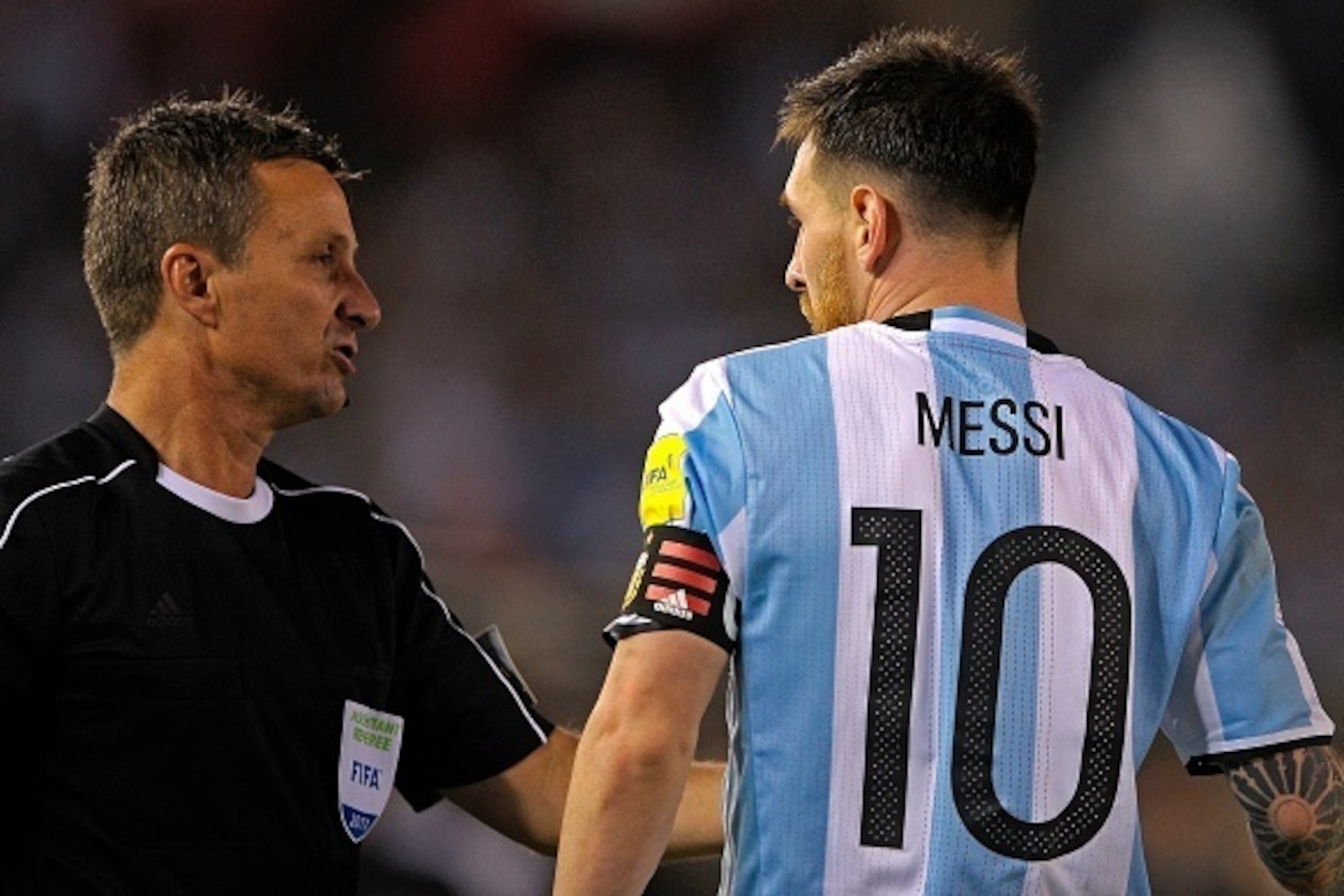 Argentina's forward Lionel Messi (R) argues with Brazilian first assistant referee Emerson Augusto de Carvalho during the half time of their 2018 FIFA World Cup Russia South American qualifier football match against Chile, at the Monumental stadium in Bue