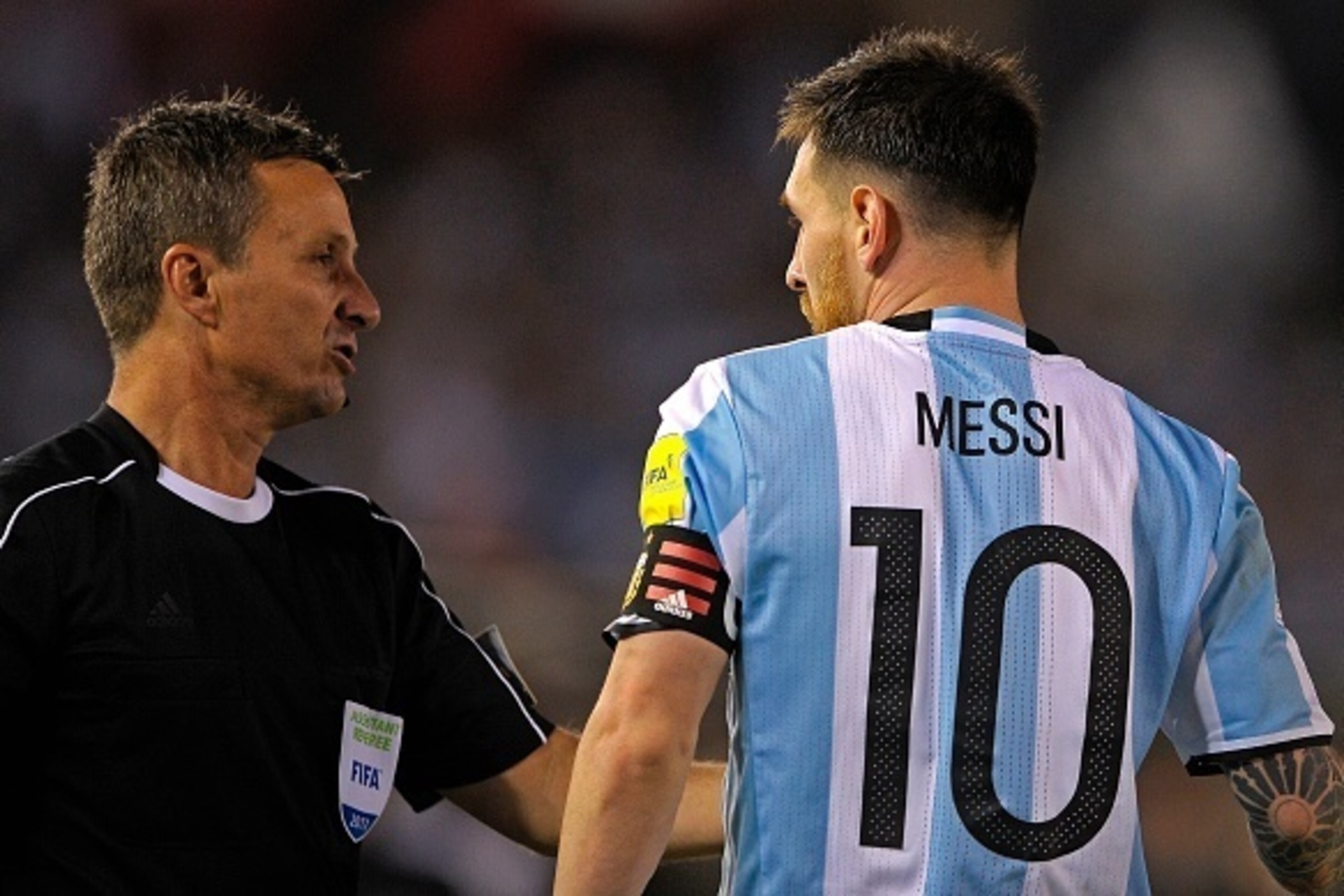 Argentina's forward Lionel Messi (R) argues with Brazilian first assistant referee Emerson Augusto de Carvalho during the half time of their 2018 FIFA World Cup Russia South American qualifier football match against Chile, at the Monumental stadium in Bue