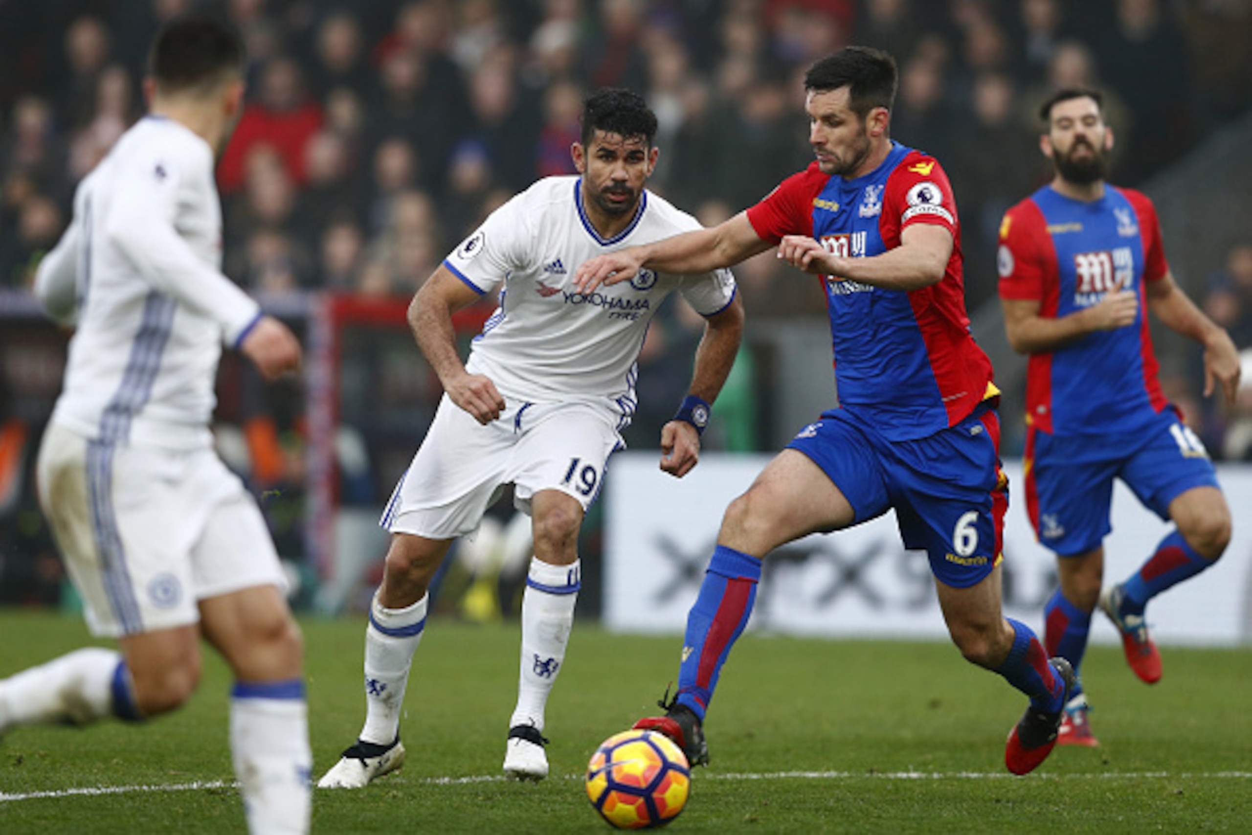 Chelsea's Brazilian-born Spanish striker Diego Costa (C) vies with Crystal Palace's English defender Scott Dann during the English Premier League football match between Crystal Palace and Chelsea at Selhurst Park in south London on December 17, 2016. / AF
