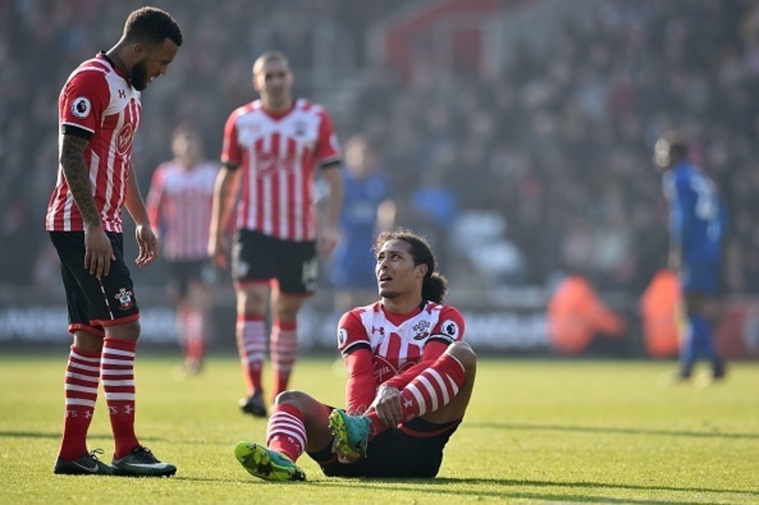 Southampton's Dutch defender Virgil van Dijk (C) sits down injured as Southampton's English defender Ryan Bertrand (L) looks on during the English Premier League football match between Southampton and Leicester City at St Mary's Stadium in Southampton, so