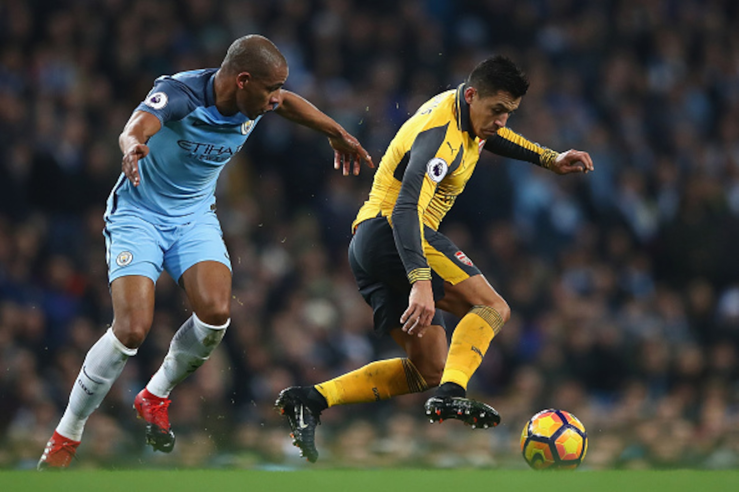 MANCHESTER, ENGLAND - DECEMBER 18:  Fernando of Manchester City (L) and Alexis Sanchez of Arsenal (R) battle for possession during the Premier League match between Manchester City and Arsenal at Etihad Stadium on December 18, 2016 in Manchester, England. 