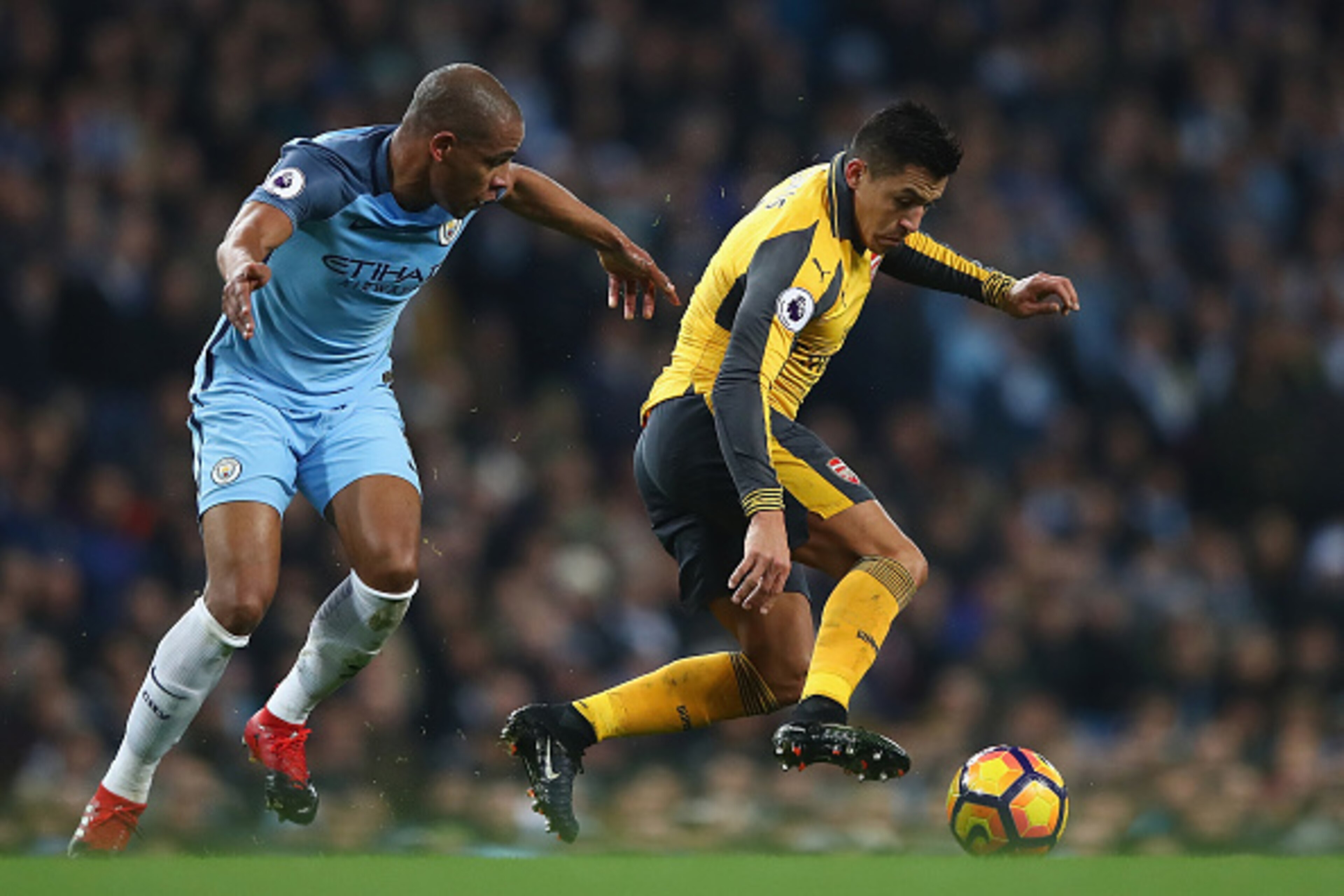 MANCHESTER, ENGLAND - DECEMBER 18:  Fernando of Manchester City (L) and Alexis Sanchez of Arsenal (R) battle for possession during the Premier League match between Manchester City and Arsenal at Etihad Stadium on December 18, 2016 in Manchester, England. 