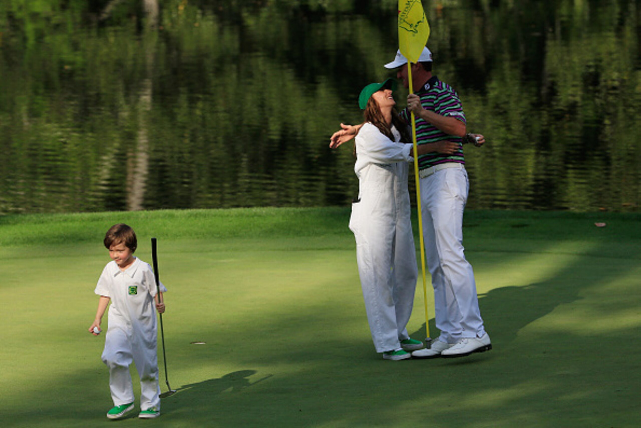 AUGUSTA, GA - APRIL 08:  Jimmy Walker of the United States embraces his wife Erin as their caddie walks off during the Par 3 Contest prior to the start of the 2015 Masters Tournament at Augusta National Golf Club on April 8, 2015 in Augusta, Georgia.  (Ph