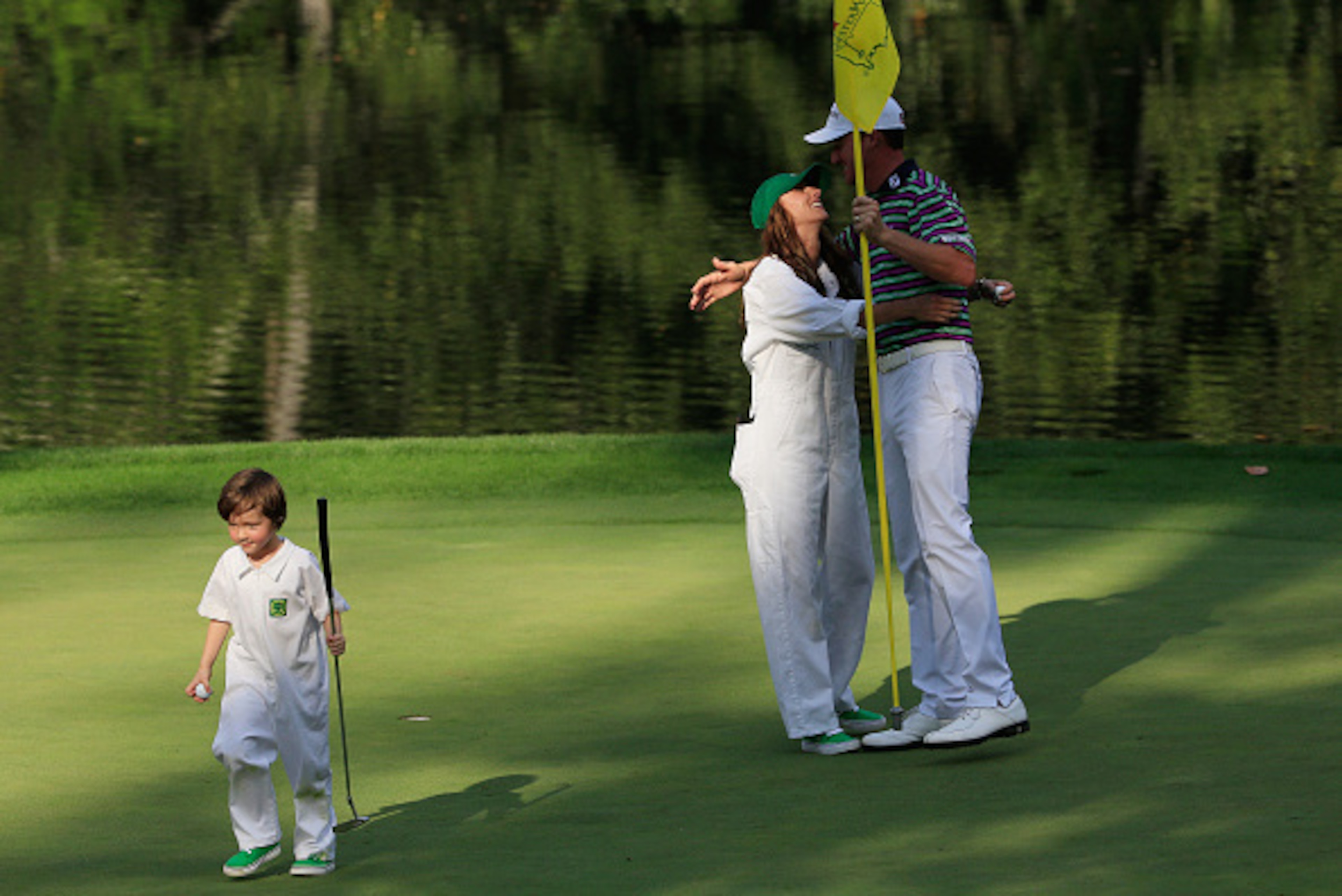 AUGUSTA, GA - APRIL 08:  Jimmy Walker of the United States embraces his wife Erin as their caddie walks off during the Par 3 Contest prior to the start of the 2015 Masters Tournament at Augusta National Golf Club on April 8, 2015 in Augusta, Georgia.  (Ph