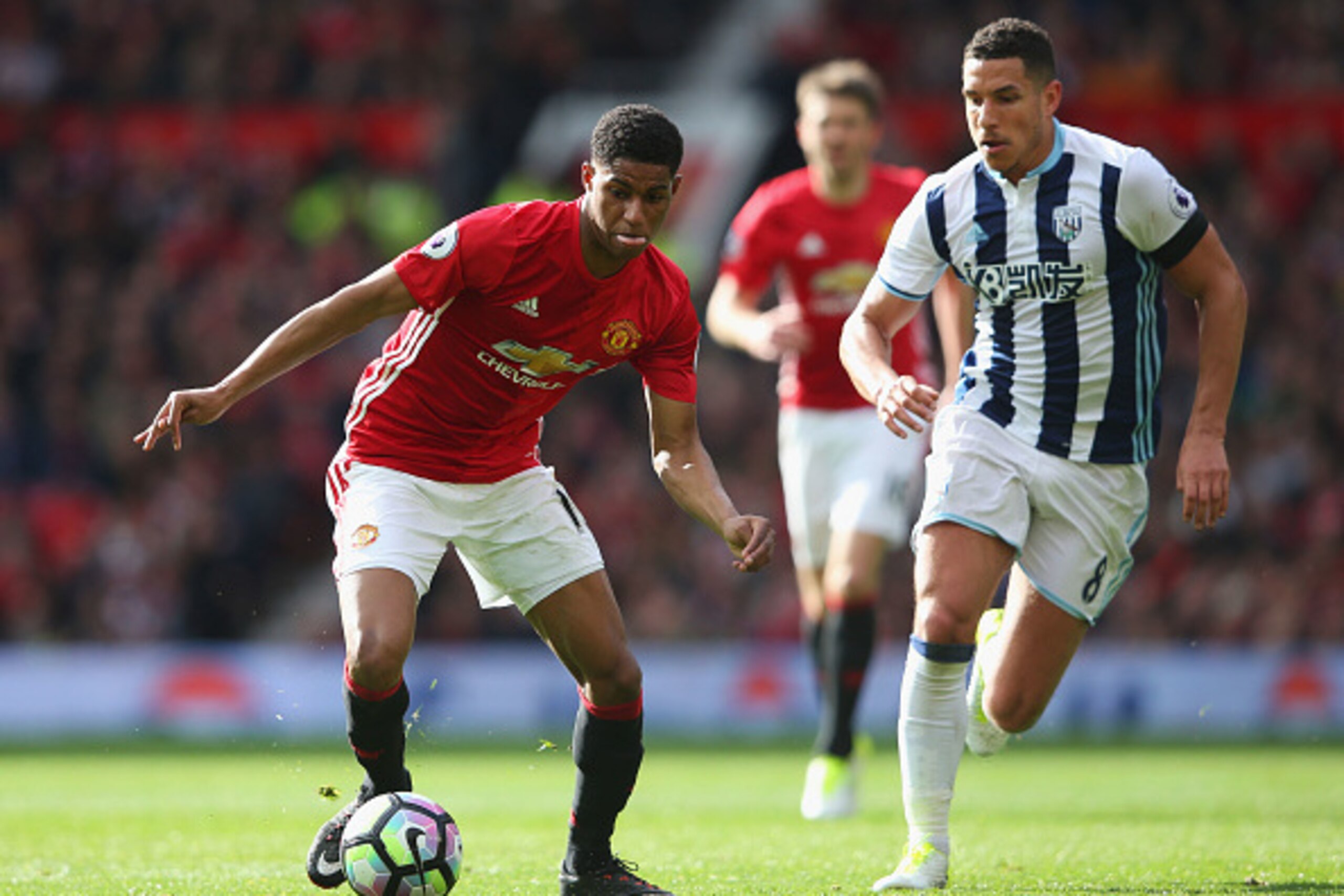 MANCHESTER, ENGLAND - APRIL 01: Marcus Rashford of Manchester United (L) attempts to take the ball past Jake Livermore of West Bromwich Albion (R) during the Premier League match between Manchester United and West Bromwich Albion at Old Trafford on April 