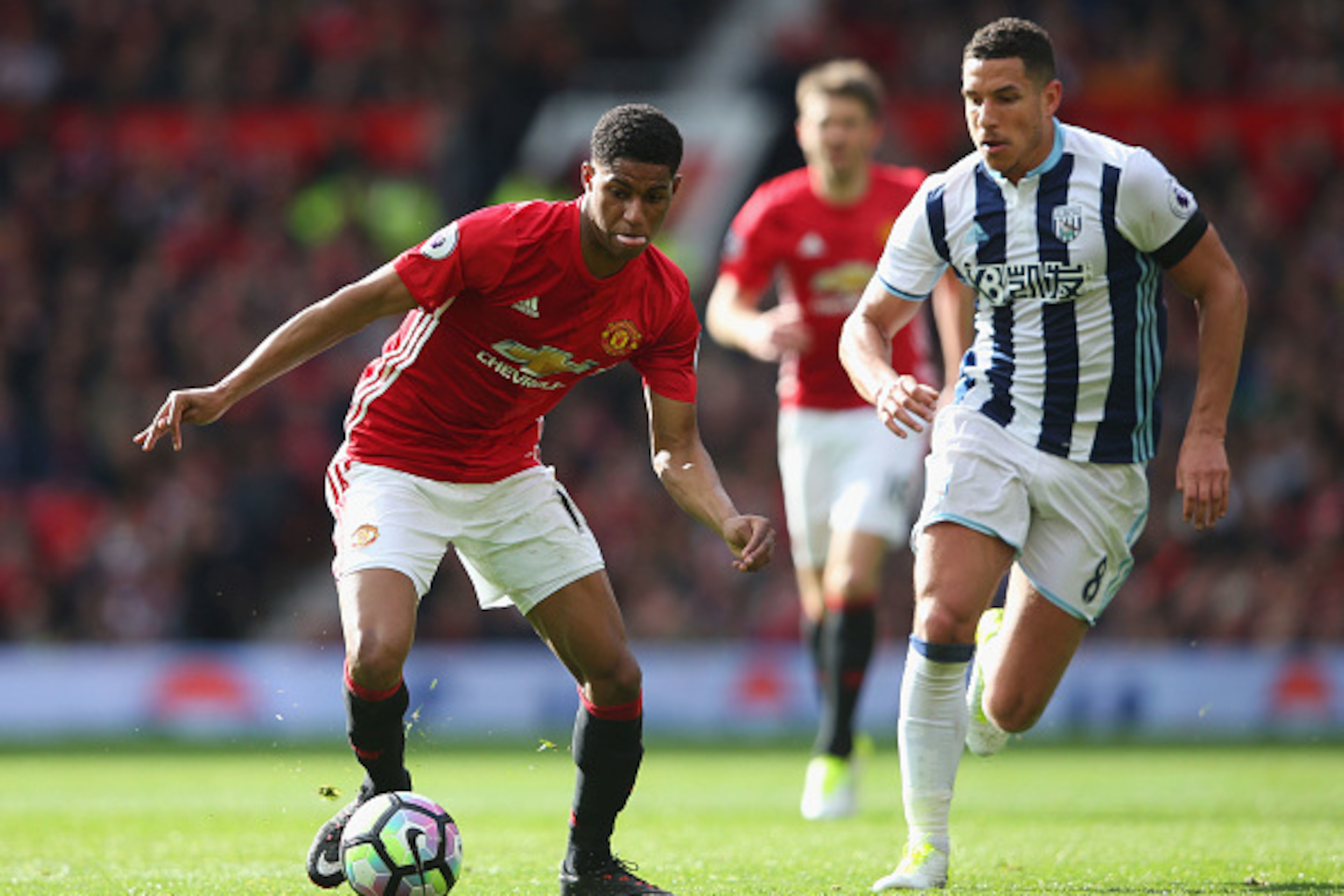 MANCHESTER, ENGLAND - APRIL 01: Marcus Rashford of Manchester United (L) attempts to take the ball past Jake Livermore of West Bromwich Albion (R) during the Premier League match between Manchester United and West Bromwich Albion at Old Trafford on April 
