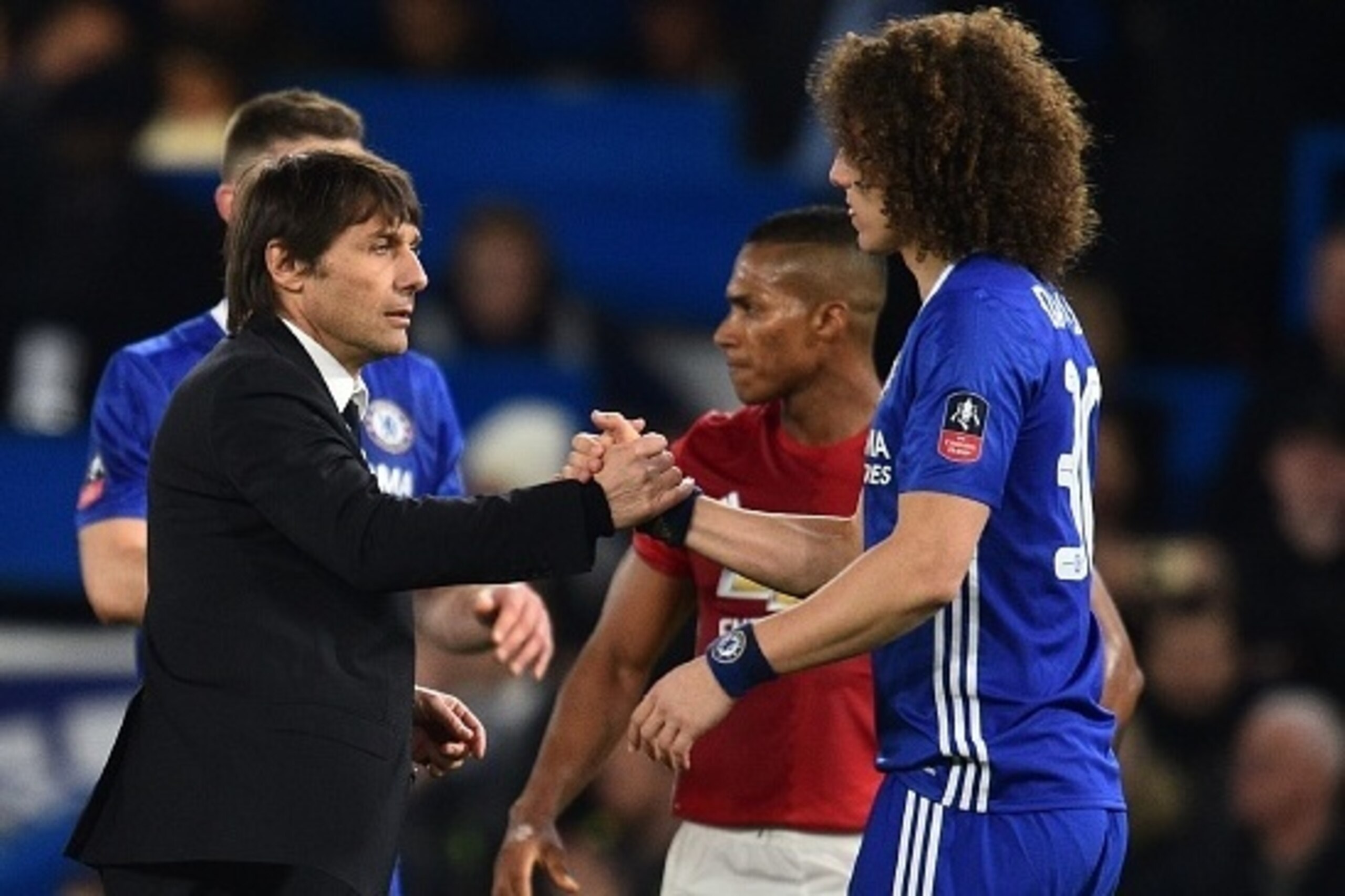 Chelsea's Italian head coach Antonio Conte (L) shakes hands with Chelsea's Brazilian defender David Luiz on the pitch after the English FA Cup quarter final football match between Chelsea and Manchester United at Stamford Bridge in London on March 13, 201