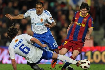 BARCELONA, SPAIN - MARCH 05:  Lionel Messi (R) of Barcelona duels for the ball with Paulo da Silva (C) and Maurizio Lanzaro of Real Zaragoza during the la Liga match between Barcelona and Real Zaragoza at the Camp Nou stadium on March 5, 2011 in Barcelona