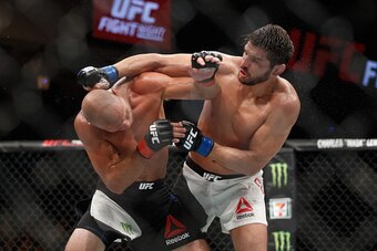 OTTAWA, ON - JUNE 18:  Patrick Cote punches Donald Cerrone in their welterweight bout during the UFC Fight Night event inside the TD Place Arena on June 18, 2016 in Ottawa, Ontario, Canada. (Photo by Andre Ringuette/Zuffa LLC/Zuffa LLC via Getty Images)